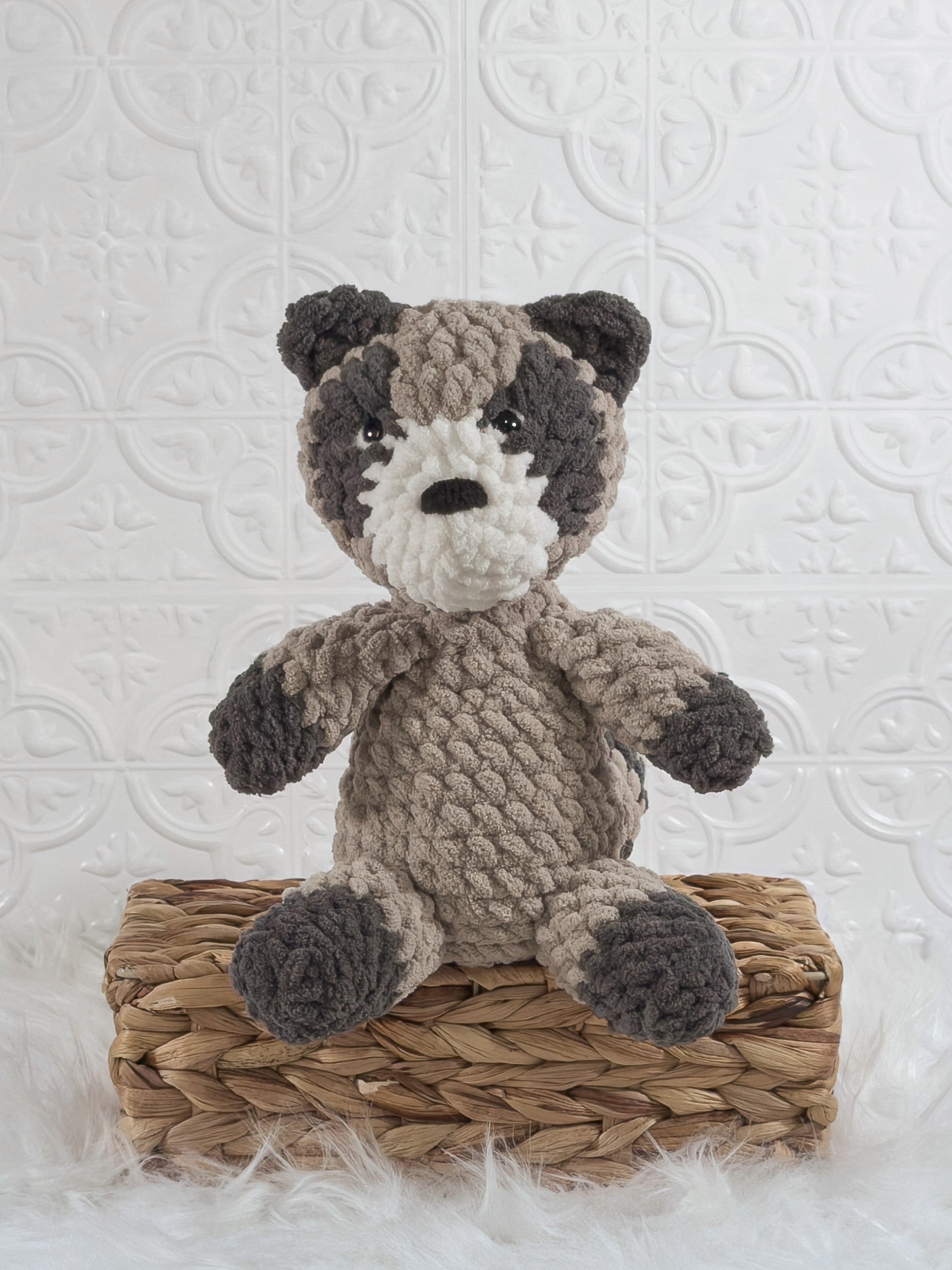 Handmade grey raccoon crochet plushie shown from the front