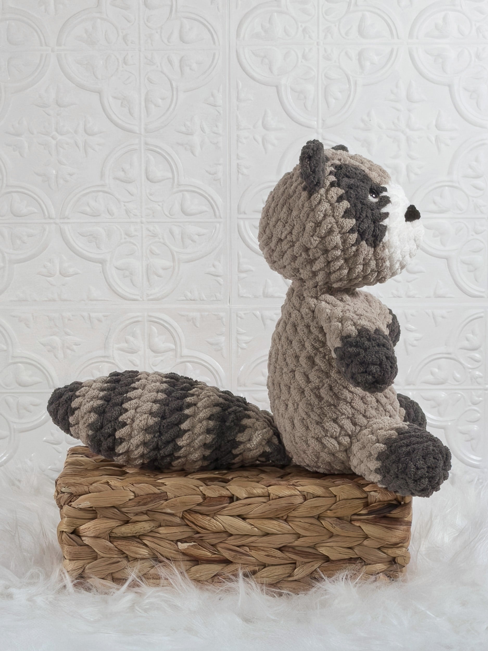 Handmade grey raccoon crochet plushie shown from the side