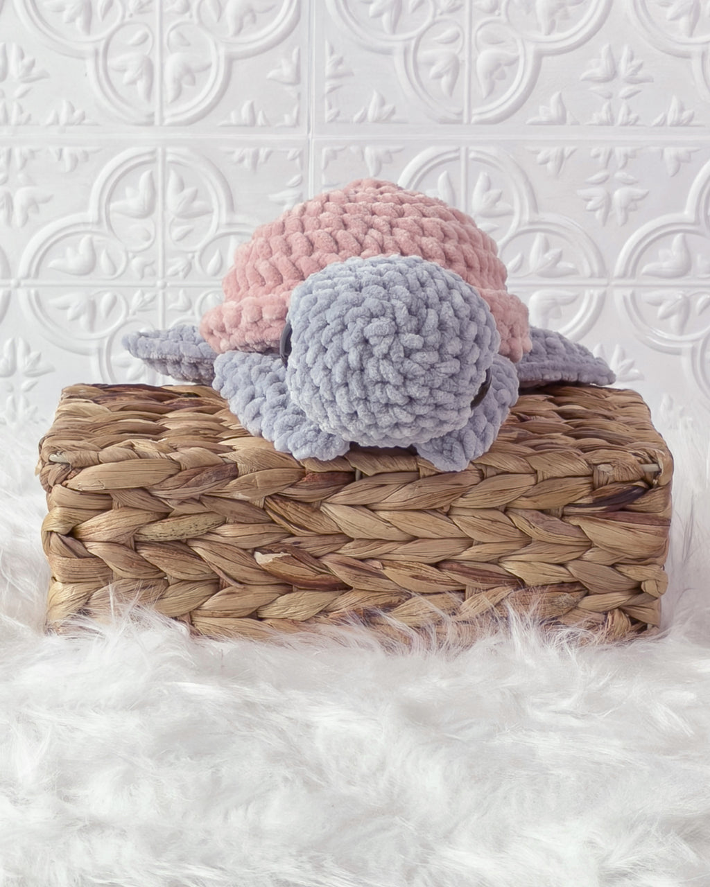 Handmade grey, pink turtle crochet plushie shown from an angled view