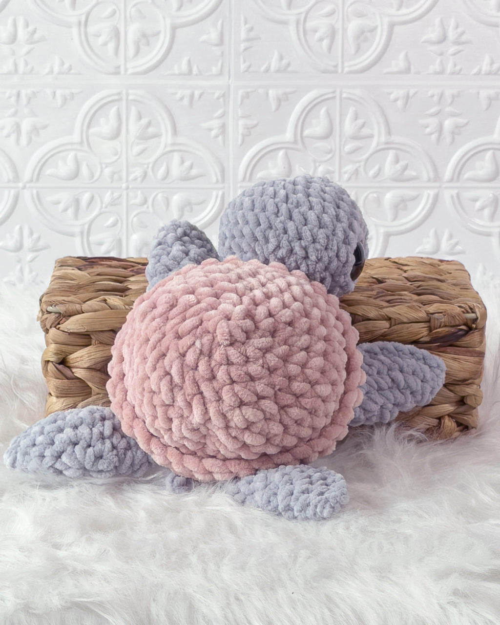 Handmade grey, pink turtle crochet plushie shown from the back