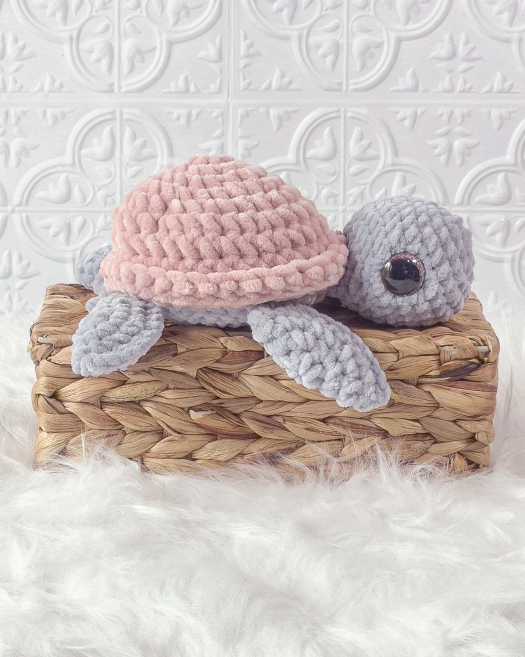 Handmade grey, pink turtle crochet plushie shown from the side