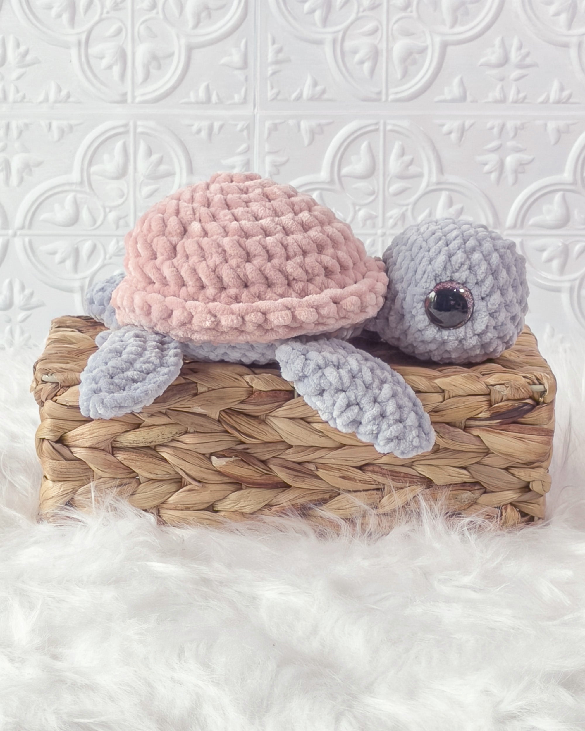 Handmade grey, pink turtle crochet plushie shown from the side