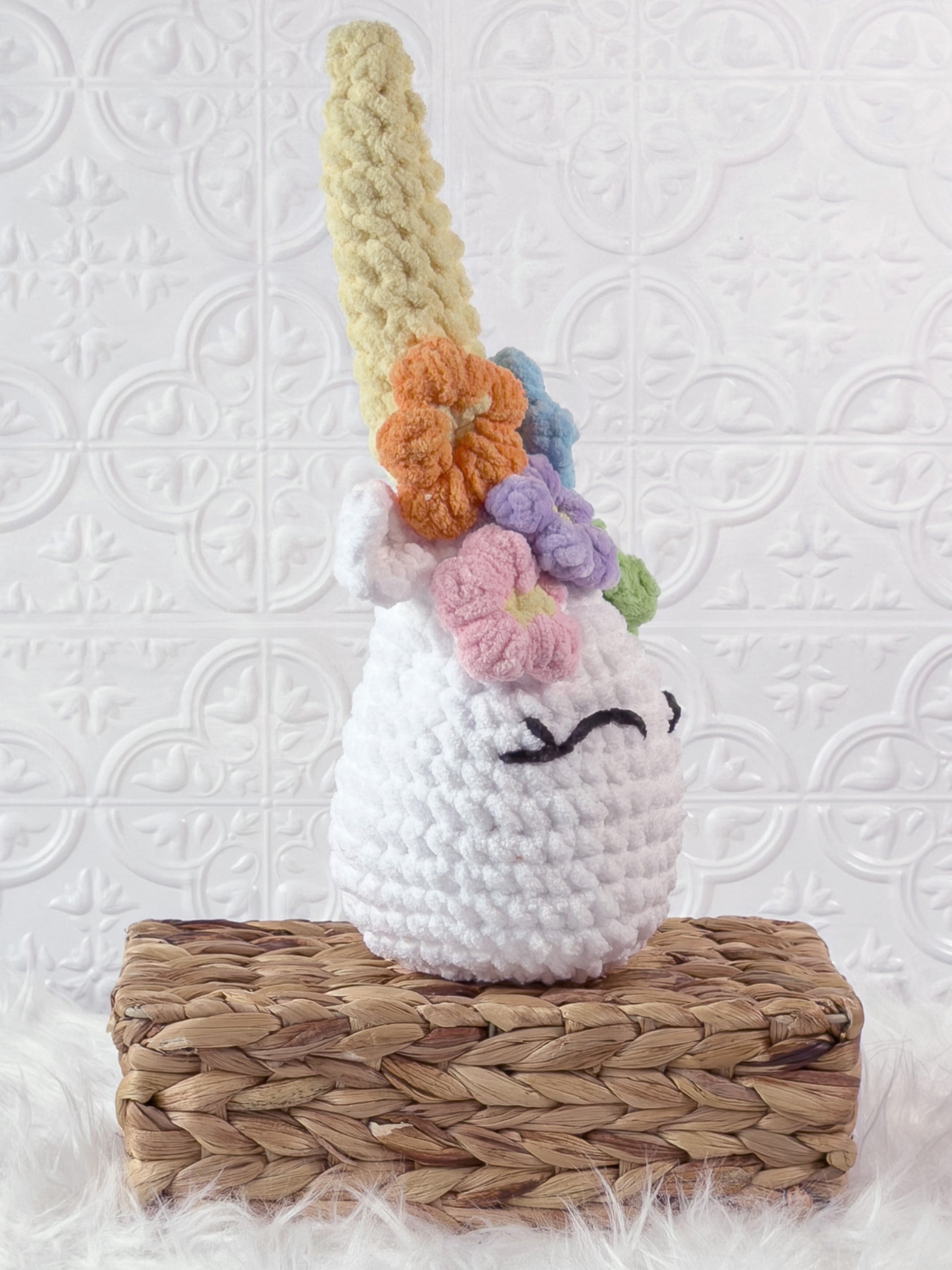 Handmade multicolor unicorn crochet plushie shown from an angled view