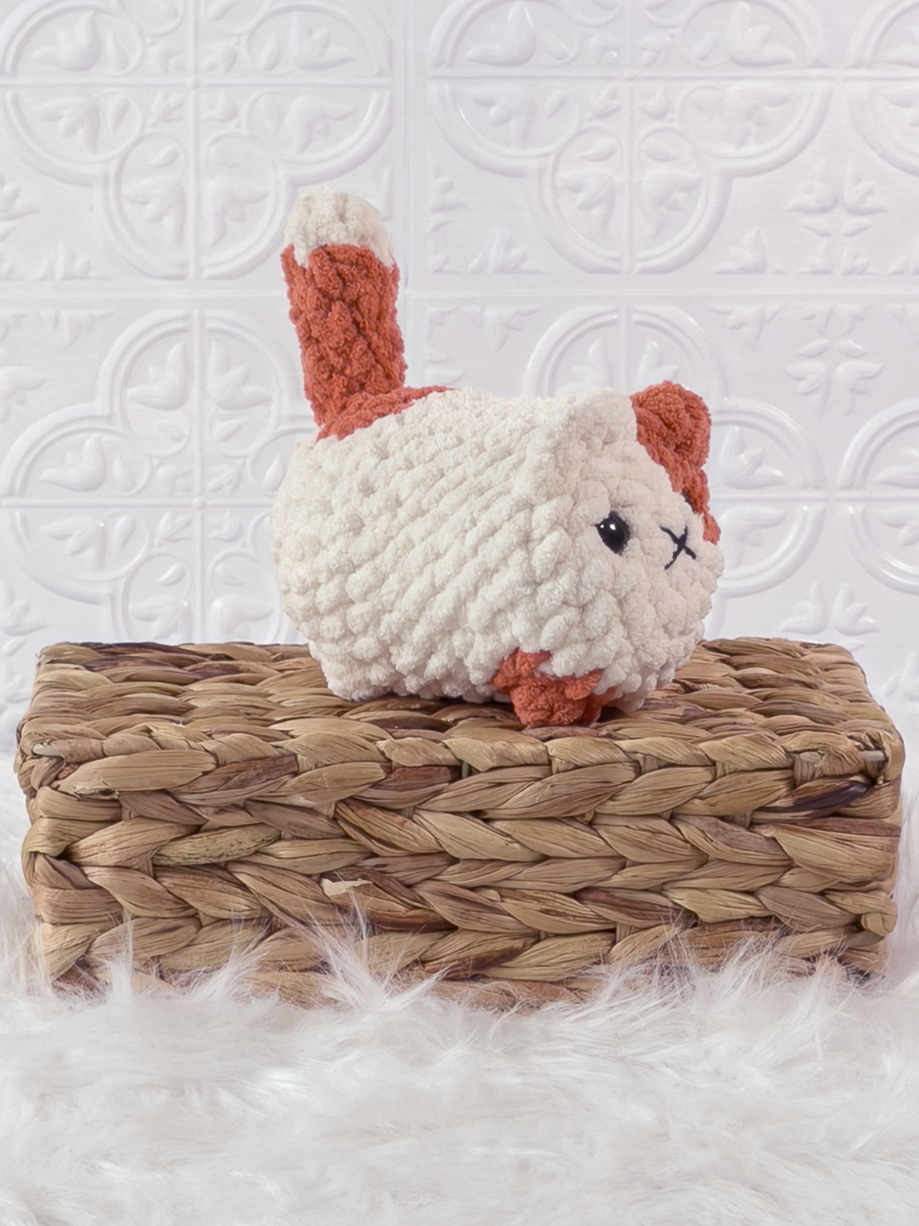 Handmade orange, cream loaf cat crochet plushie shown from an angled view