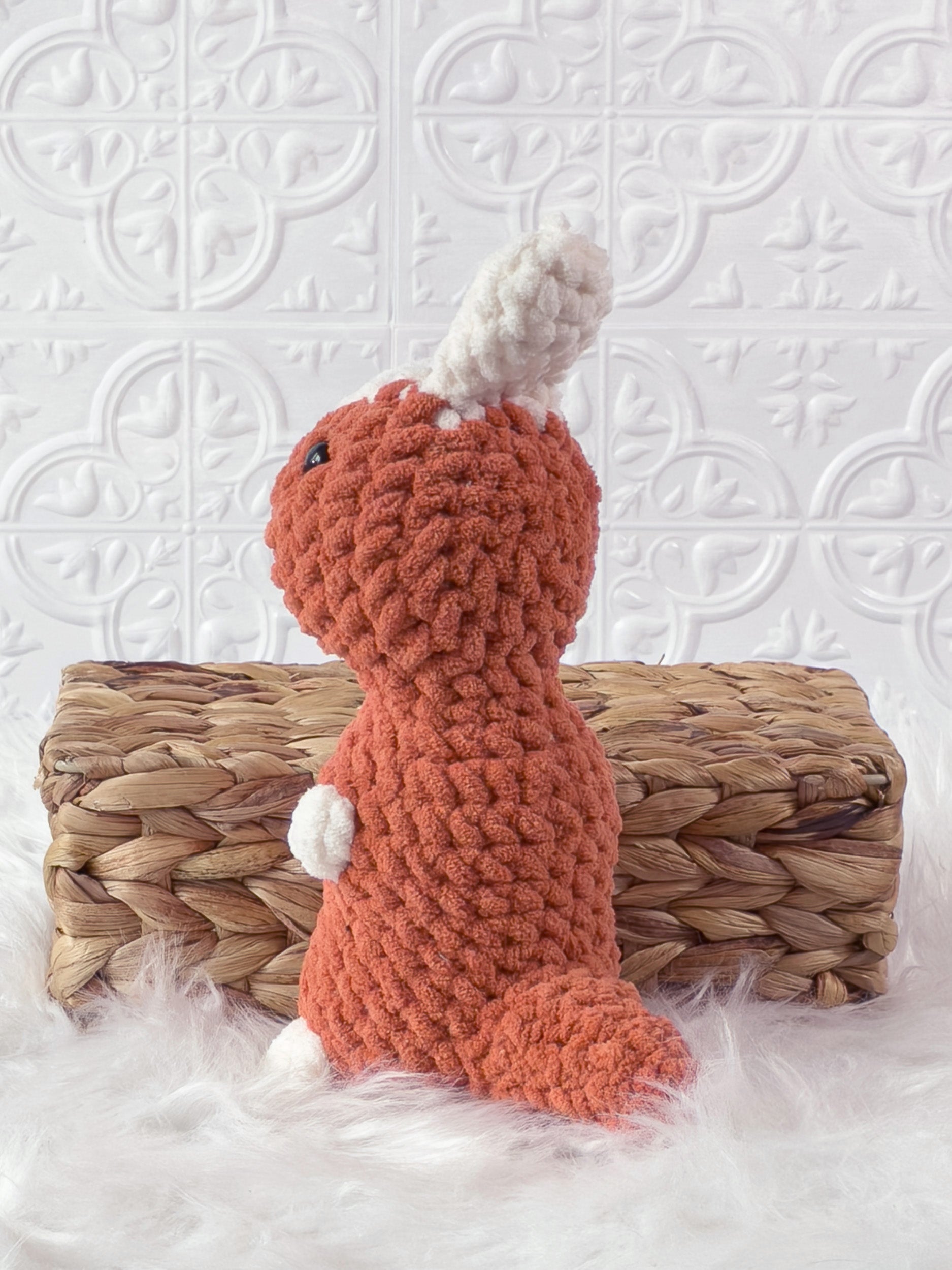 Handmade orange parasaurolophus crochet plushie shown from the back