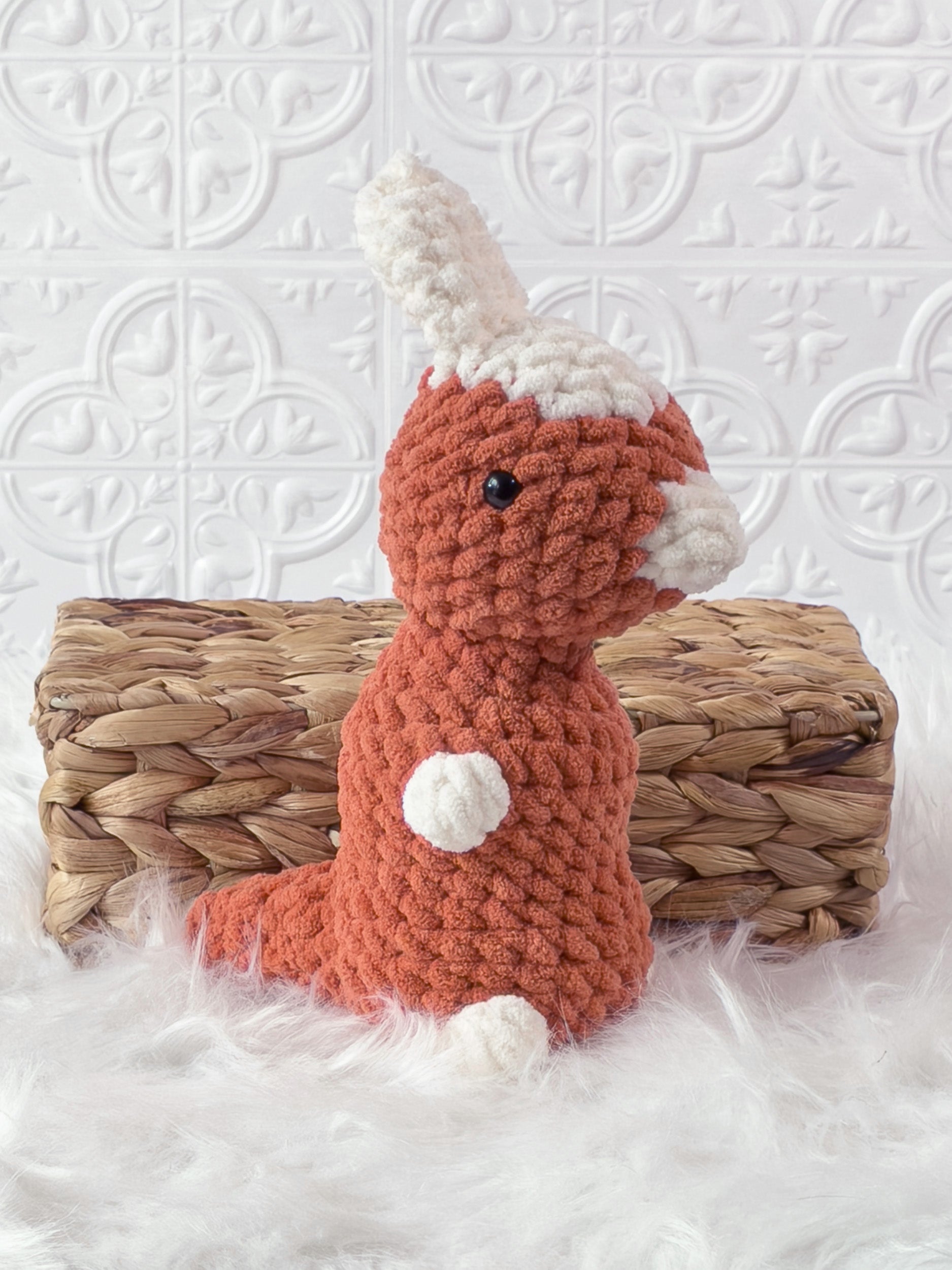 Handmade orange parasaurolophus crochet plushie shown from the side