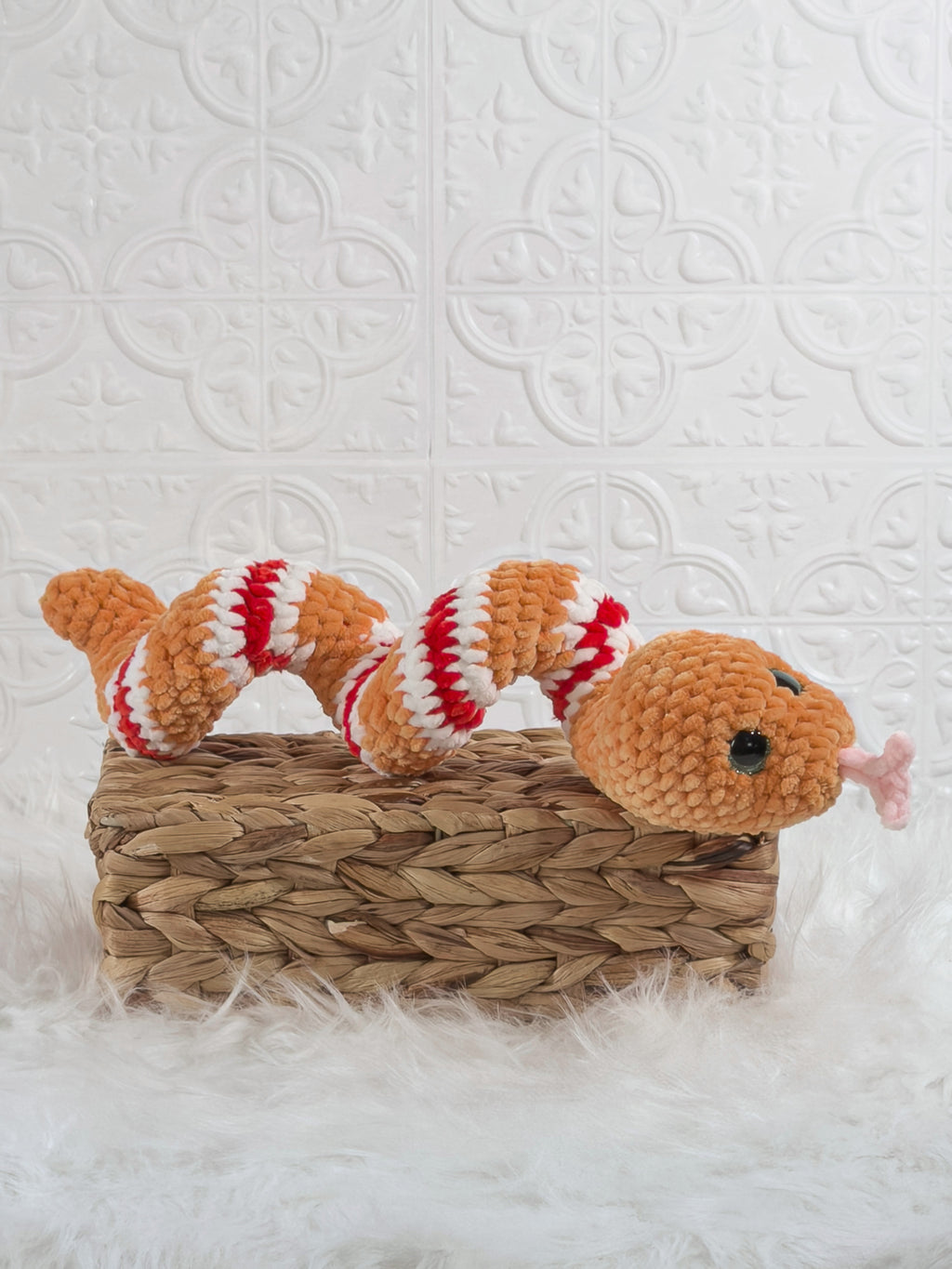 Handmade orange snake crochet plushie shown from an angled view