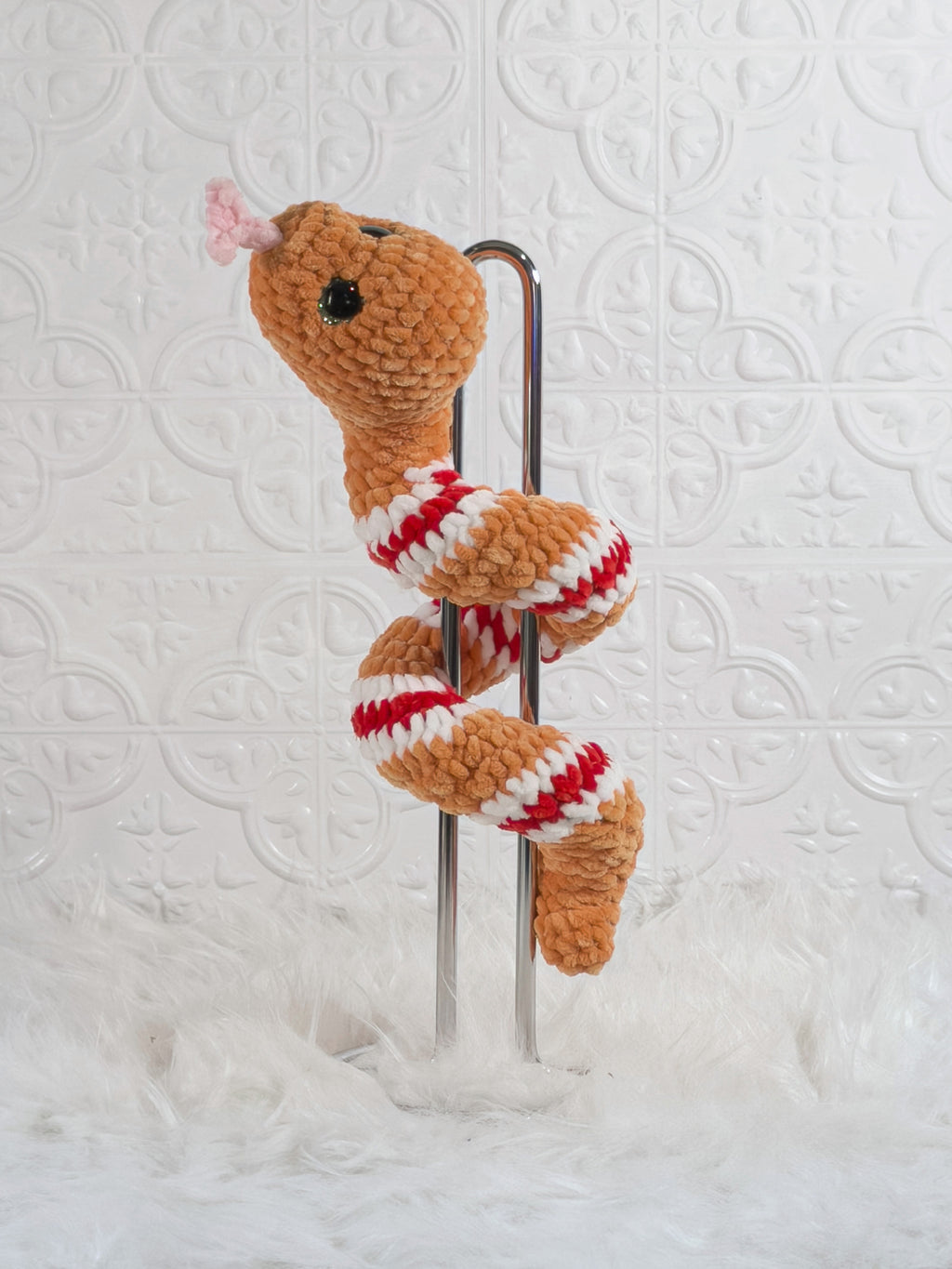 Handmade orange snake crochet plushie shown from the back