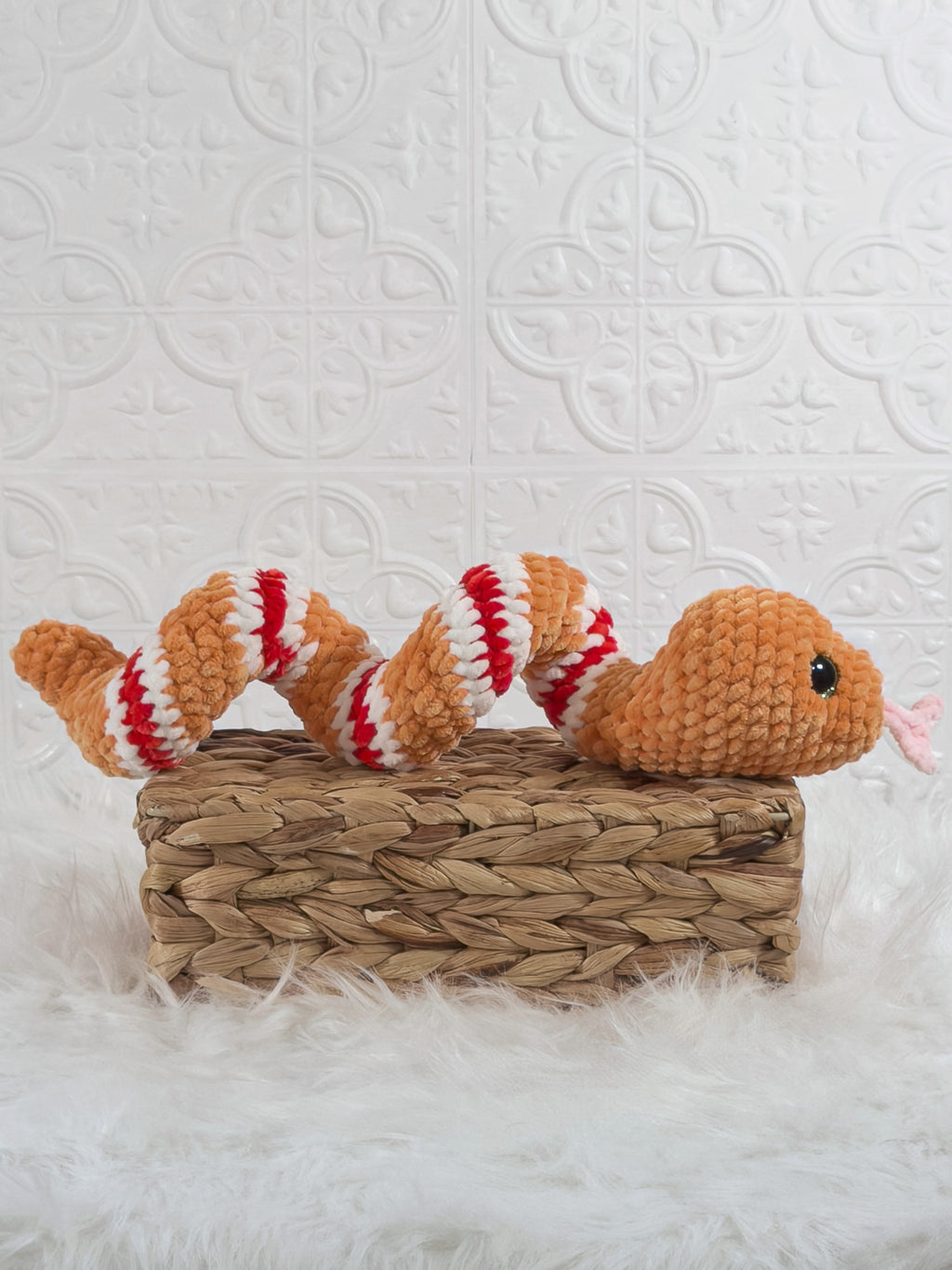 Handmade orange snake crochet plushie shown from the side