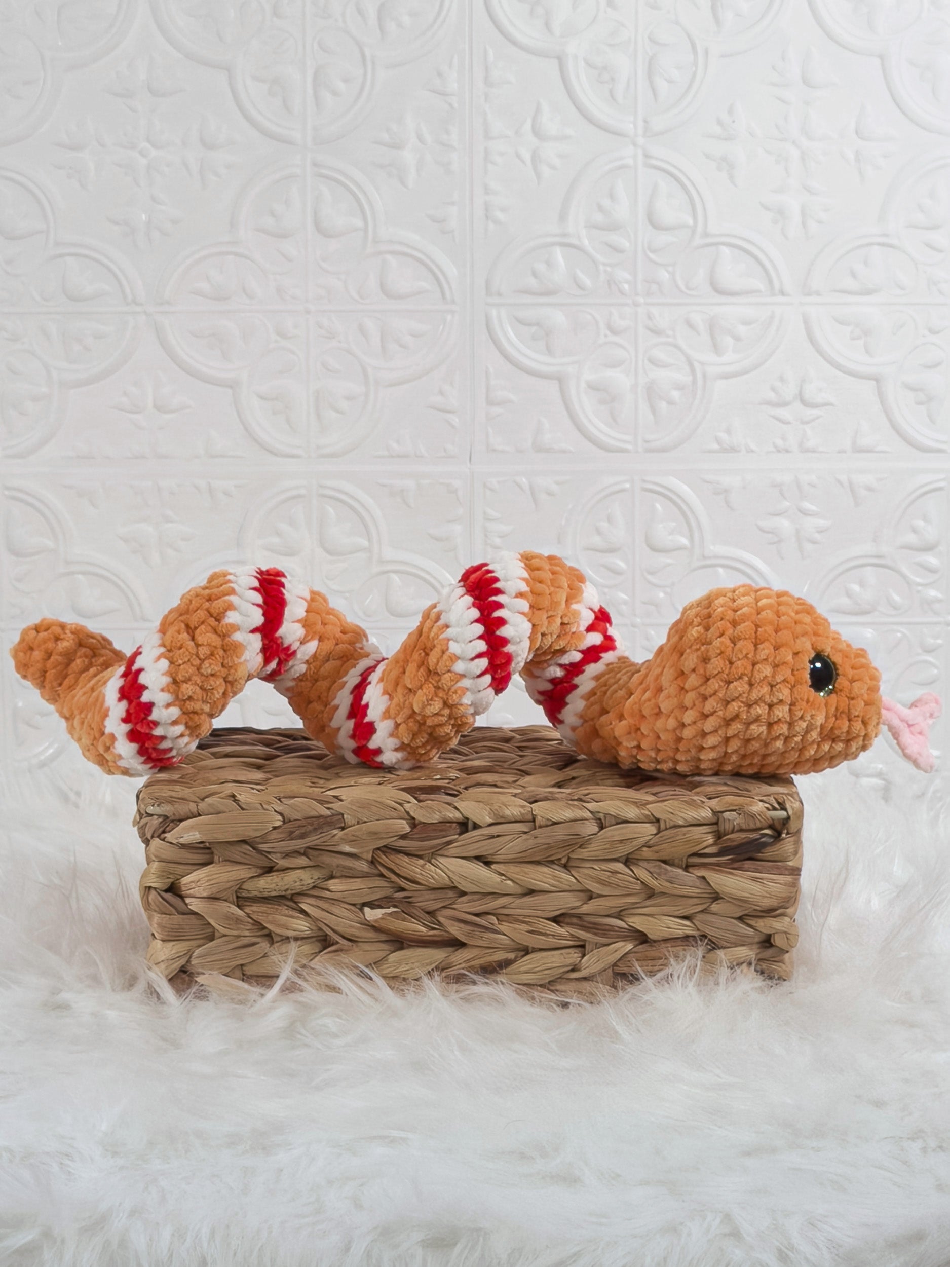 Handmade orange snake crochet plushie shown from the side