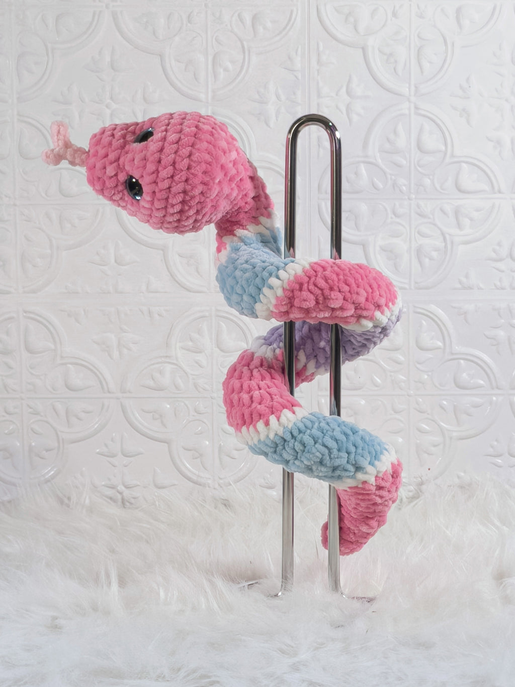 Handmade pink and blue snake crochet plushie shown from the back