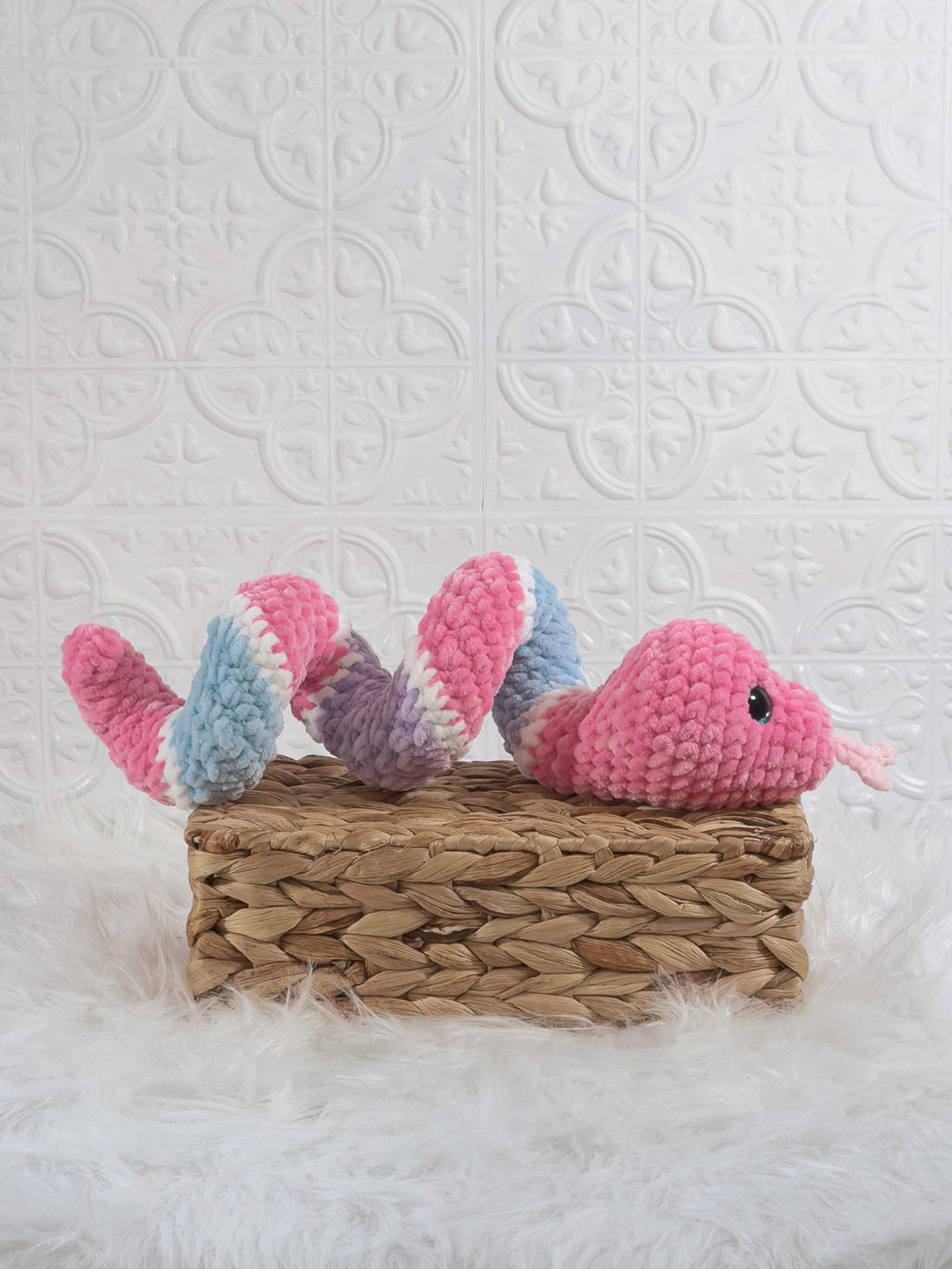 Handmade pink and blue snake crochet plushie shown from the side