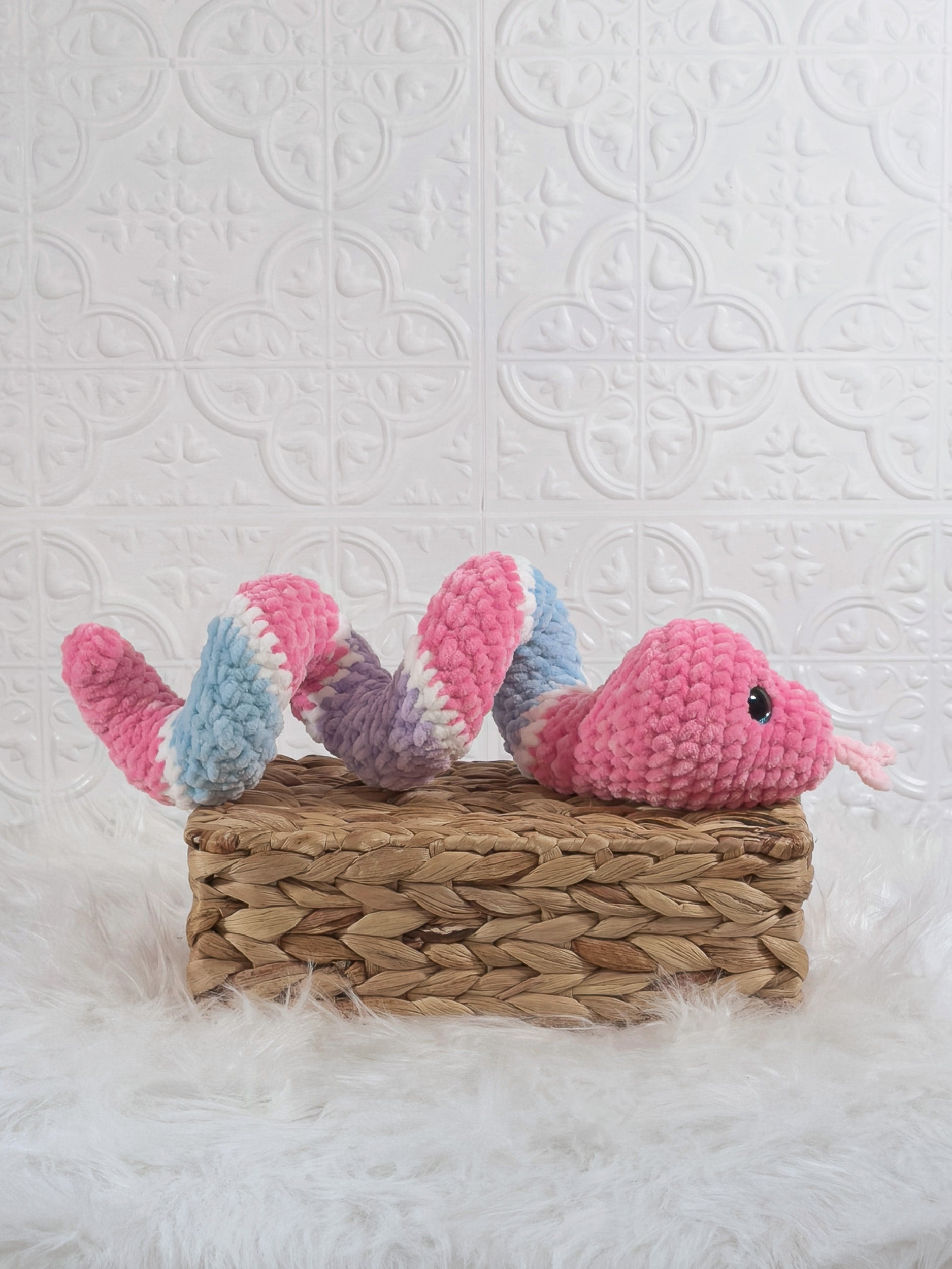 Handmade pink and blue snake crochet plushie shown from the side