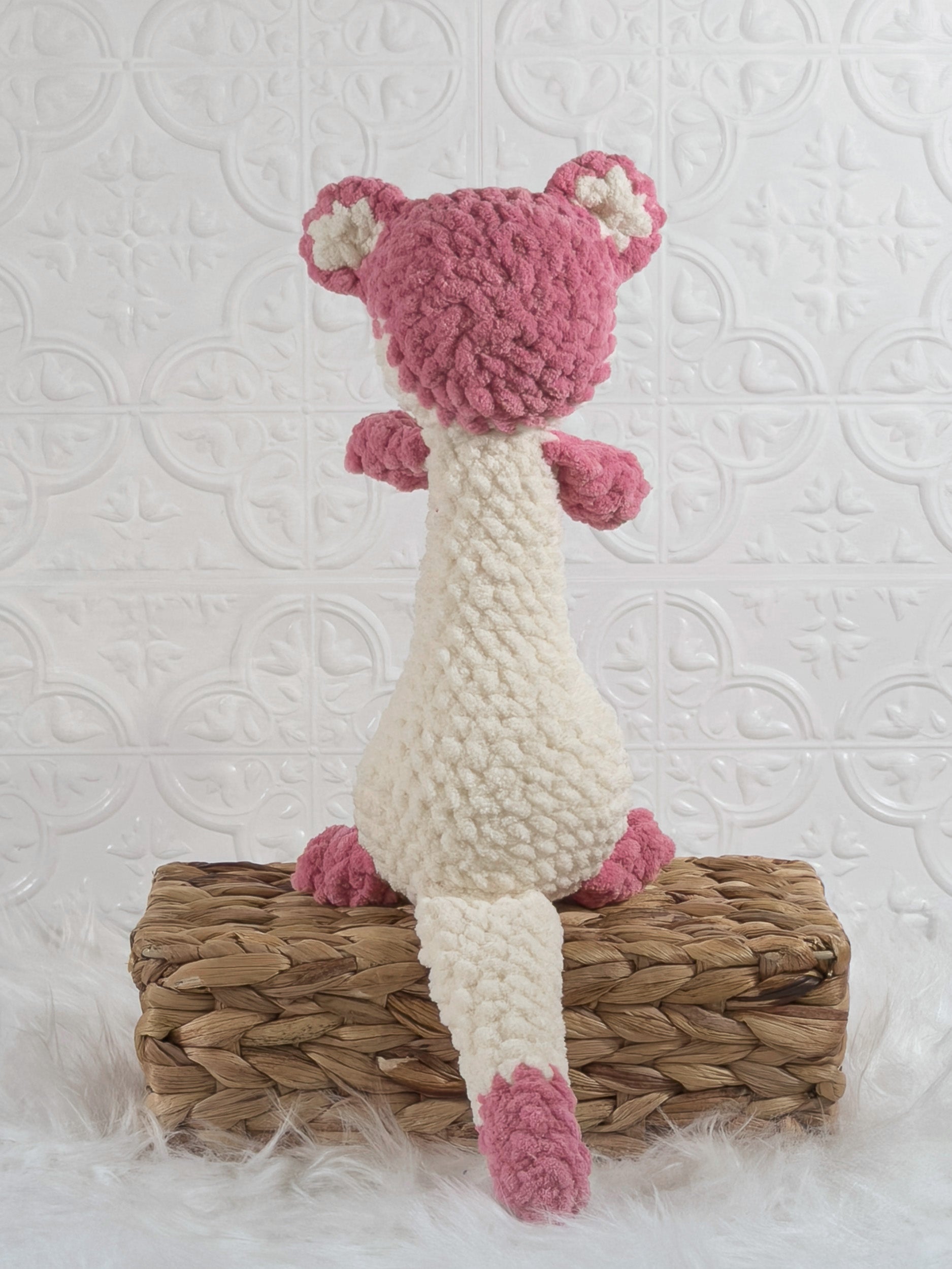 Handmade pink ferret crochet plushie shown from the back
