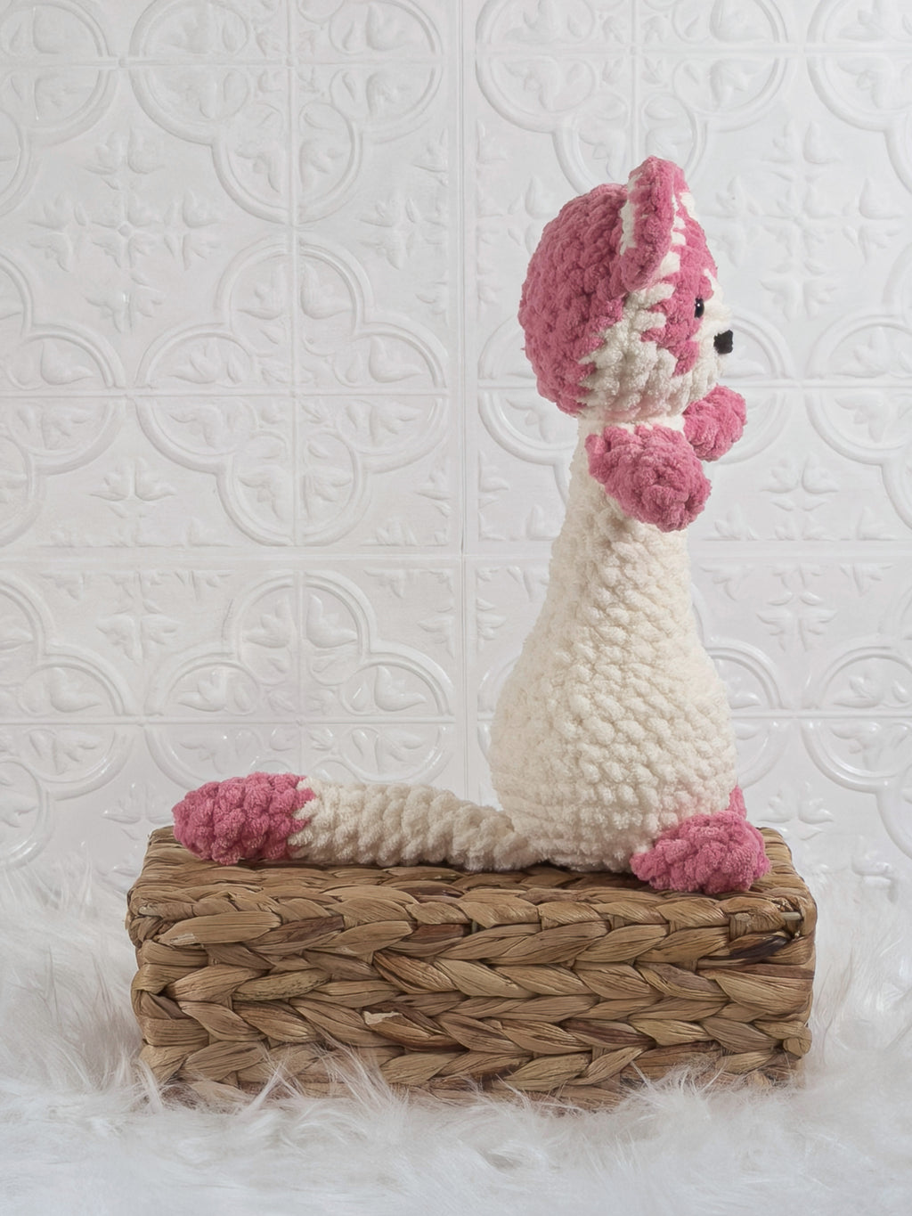 Handmade pink ferret crochet plushie shown from the side