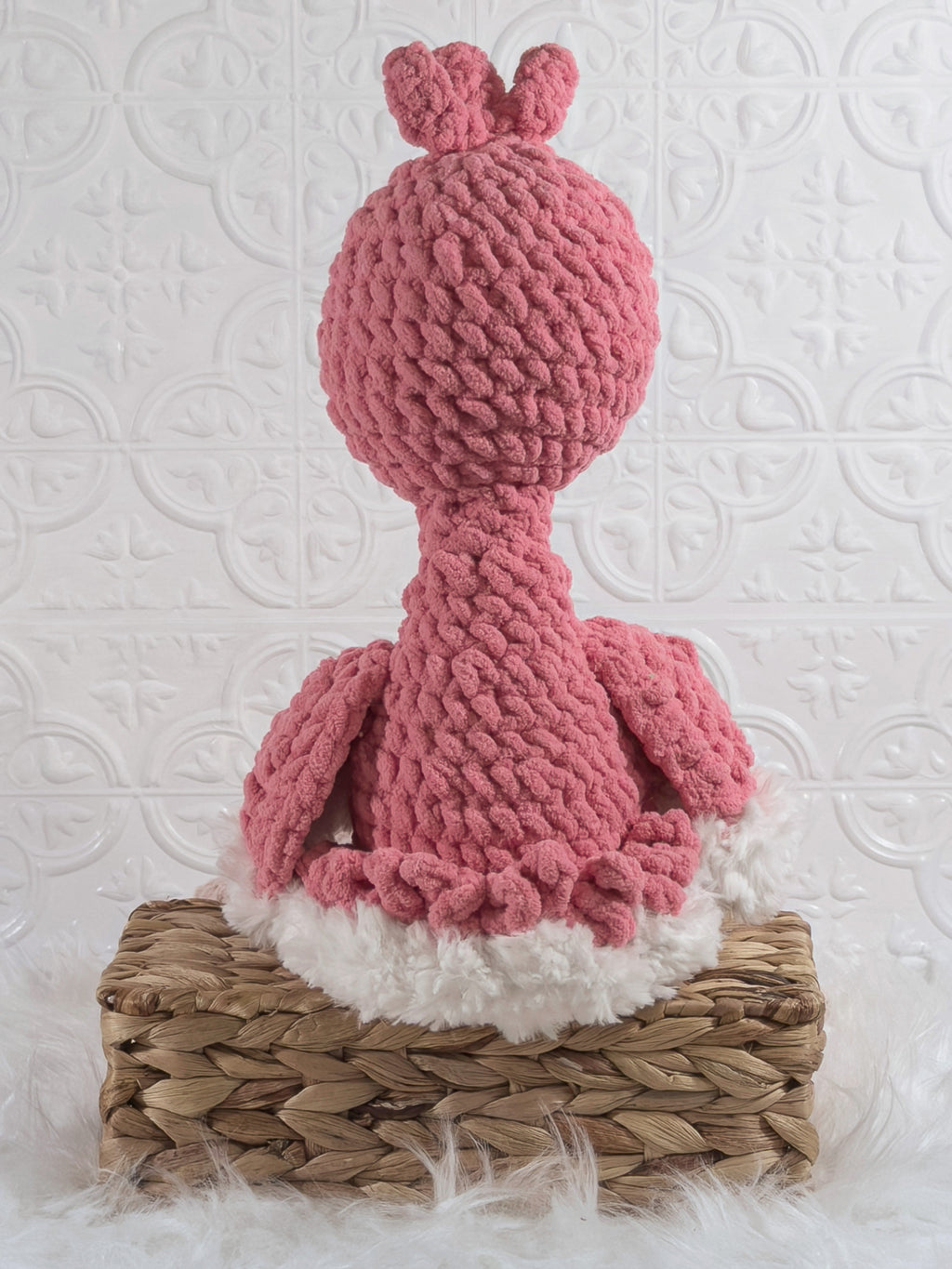 Handmade pink flamingo crochet plushie shown from the back