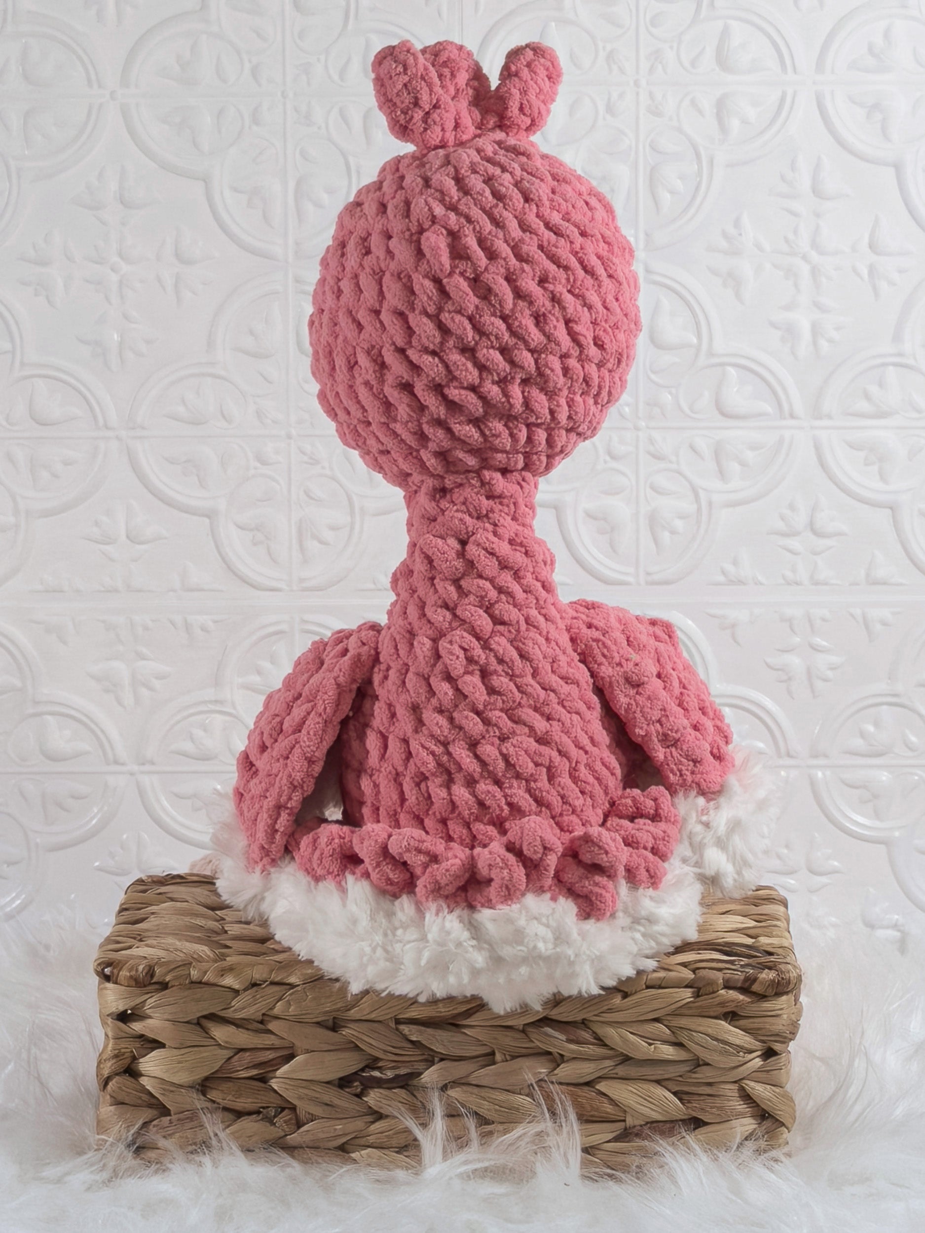 Handmade pink flamingo crochet plushie shown from the back