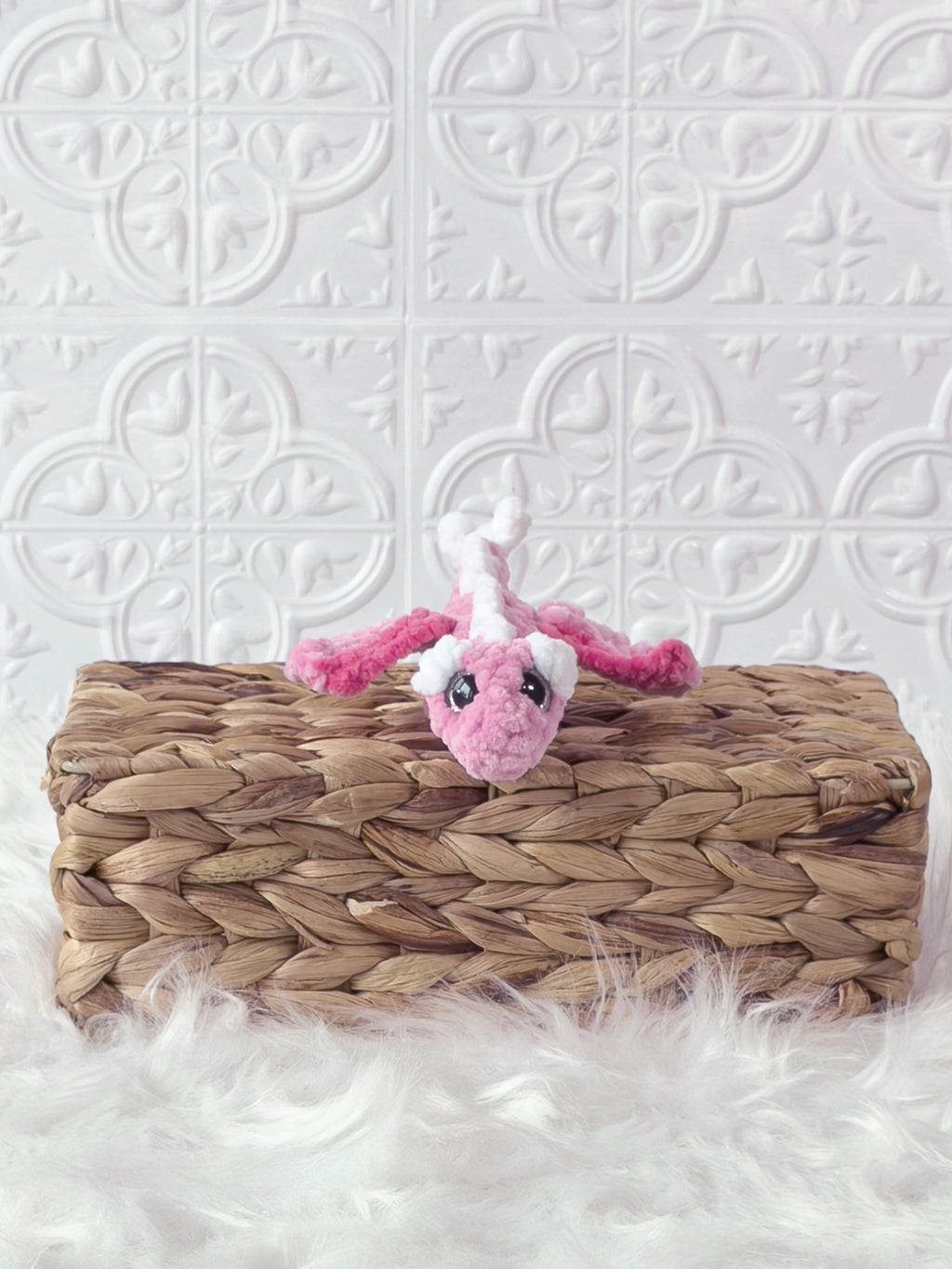 Handmade pink mini dragon crochet plushie shown from the side