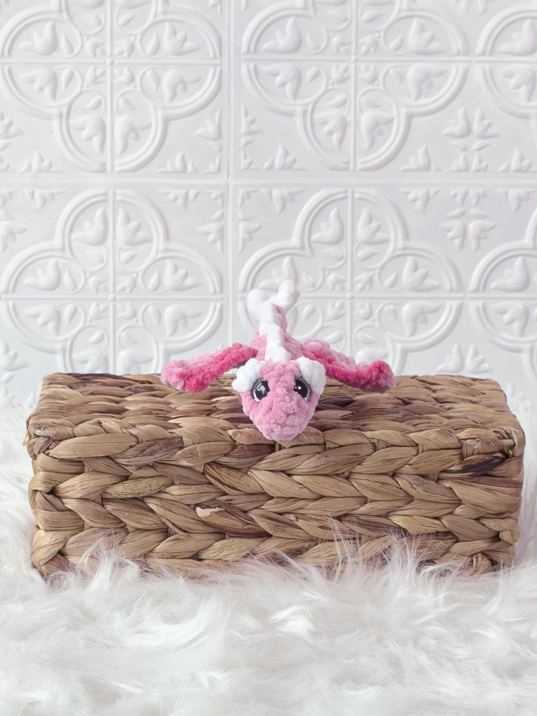 Handmade pink mini dragon crochet plushie shown from the side