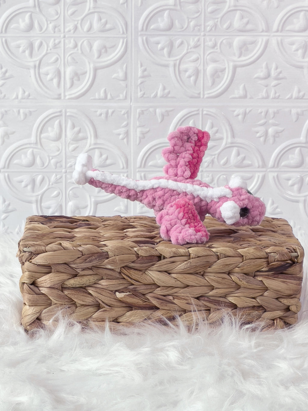 Handmade pink mini dragon crochet plushie shown from an angled view