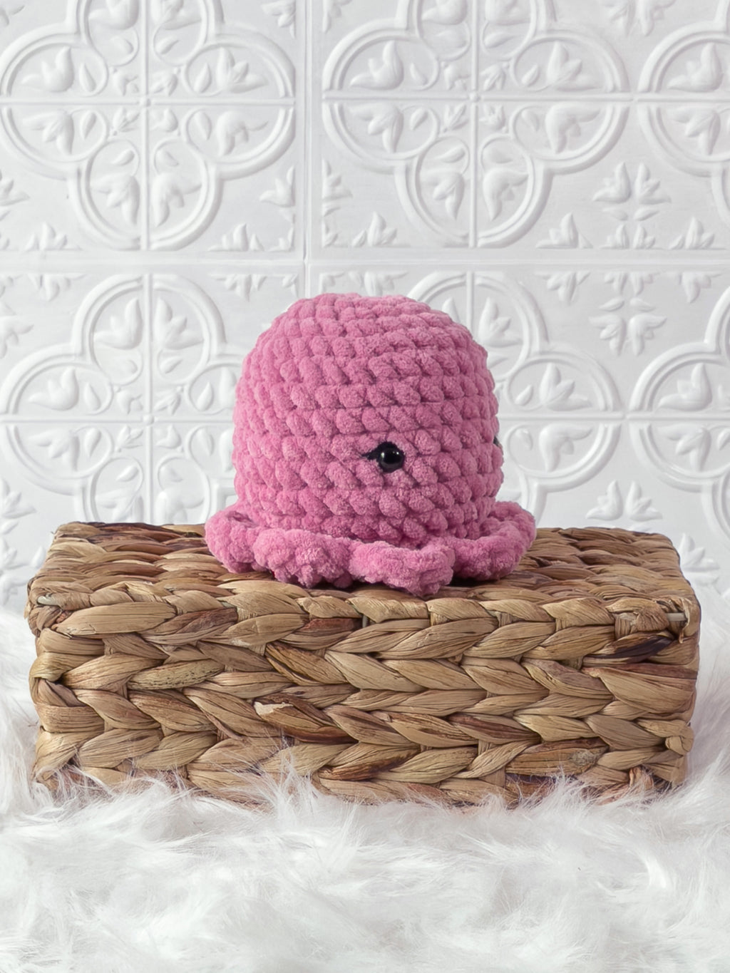 Handmade pink octopus crochet plushie shown from an angled view