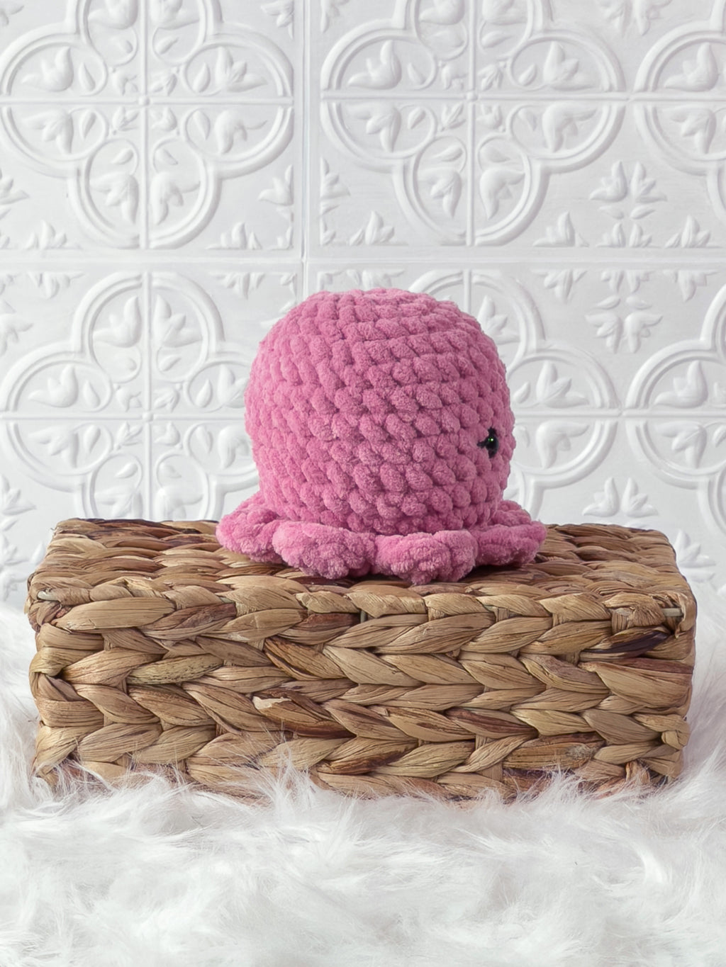 Handmade pink octopus crochet plushie shown from the side