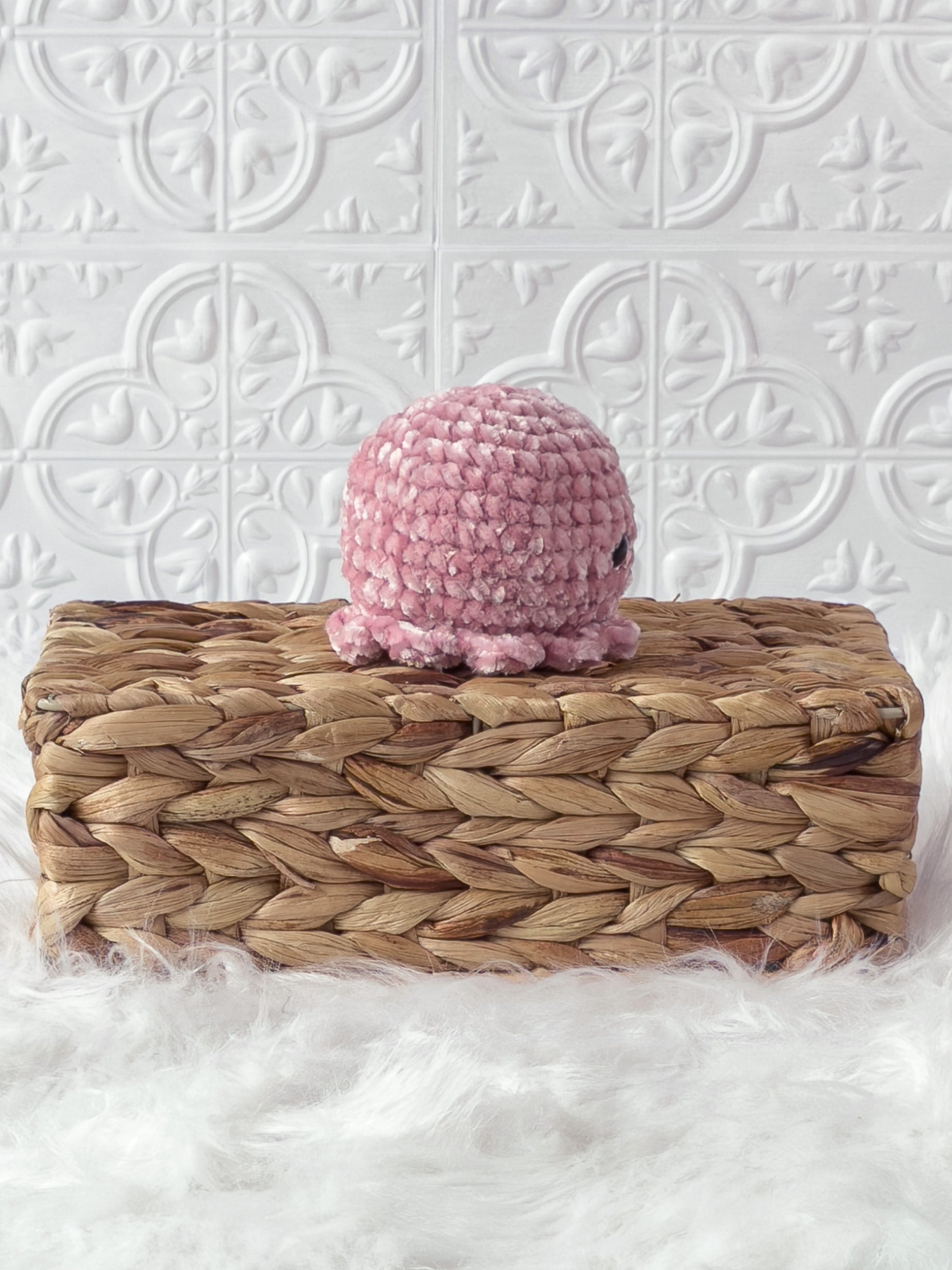 Handmade pink octopus crochet plushie shown from the side