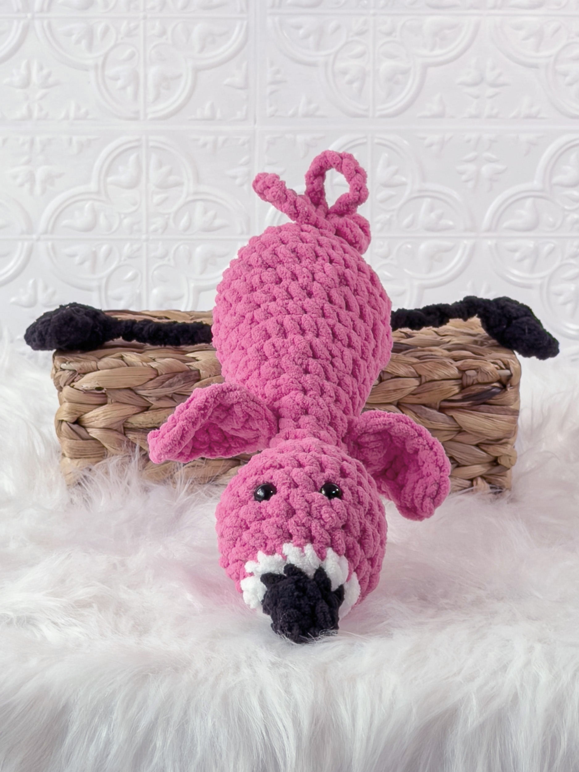 Handmade pink silly flamingo crochet plushie shown from an angled view