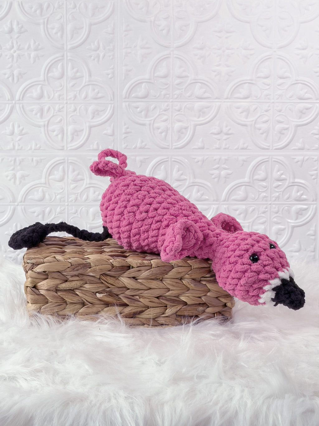 Handmade pink silly flamingo crochet plushie shown from the side