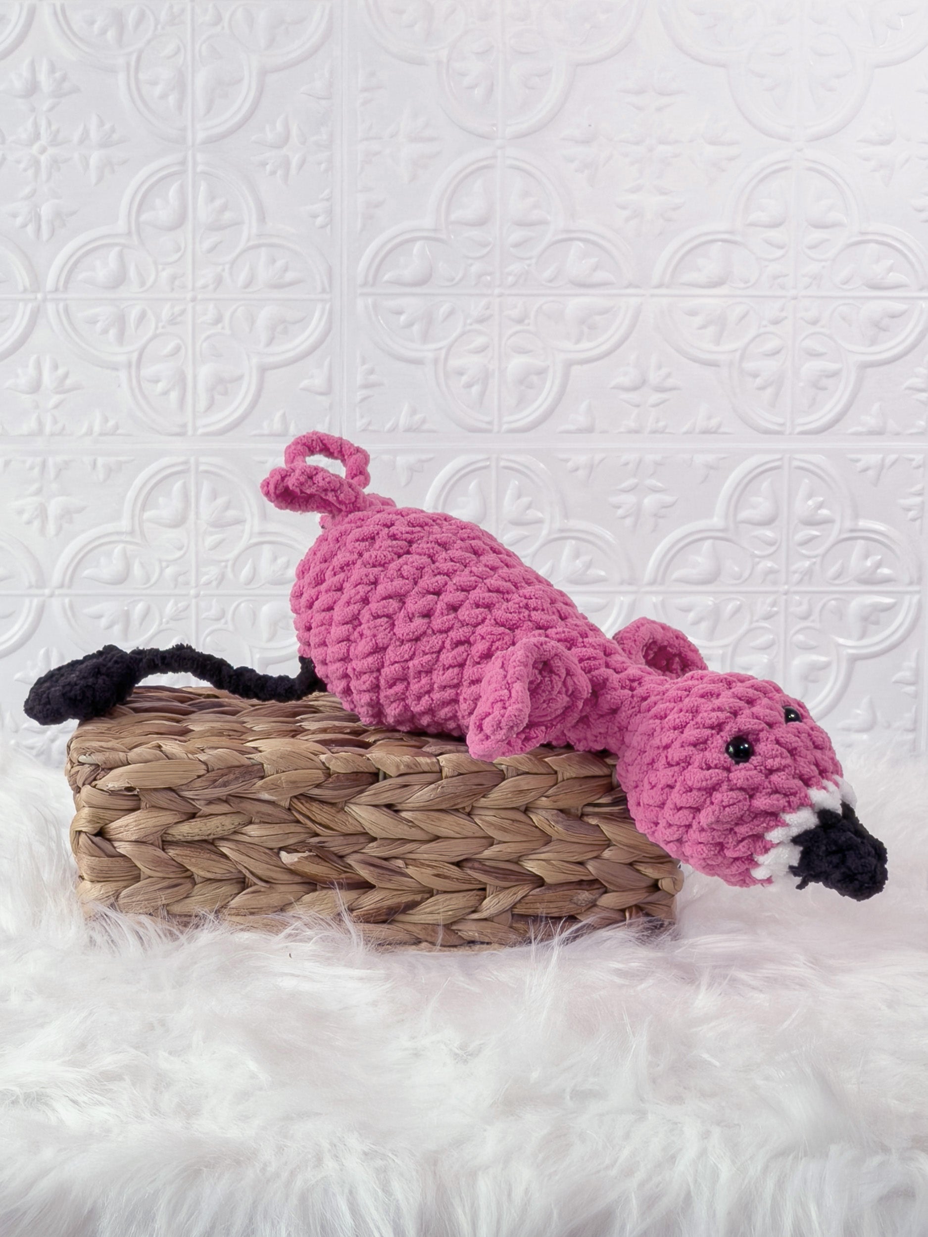 Handmade pink silly flamingo crochet plushie shown from the side