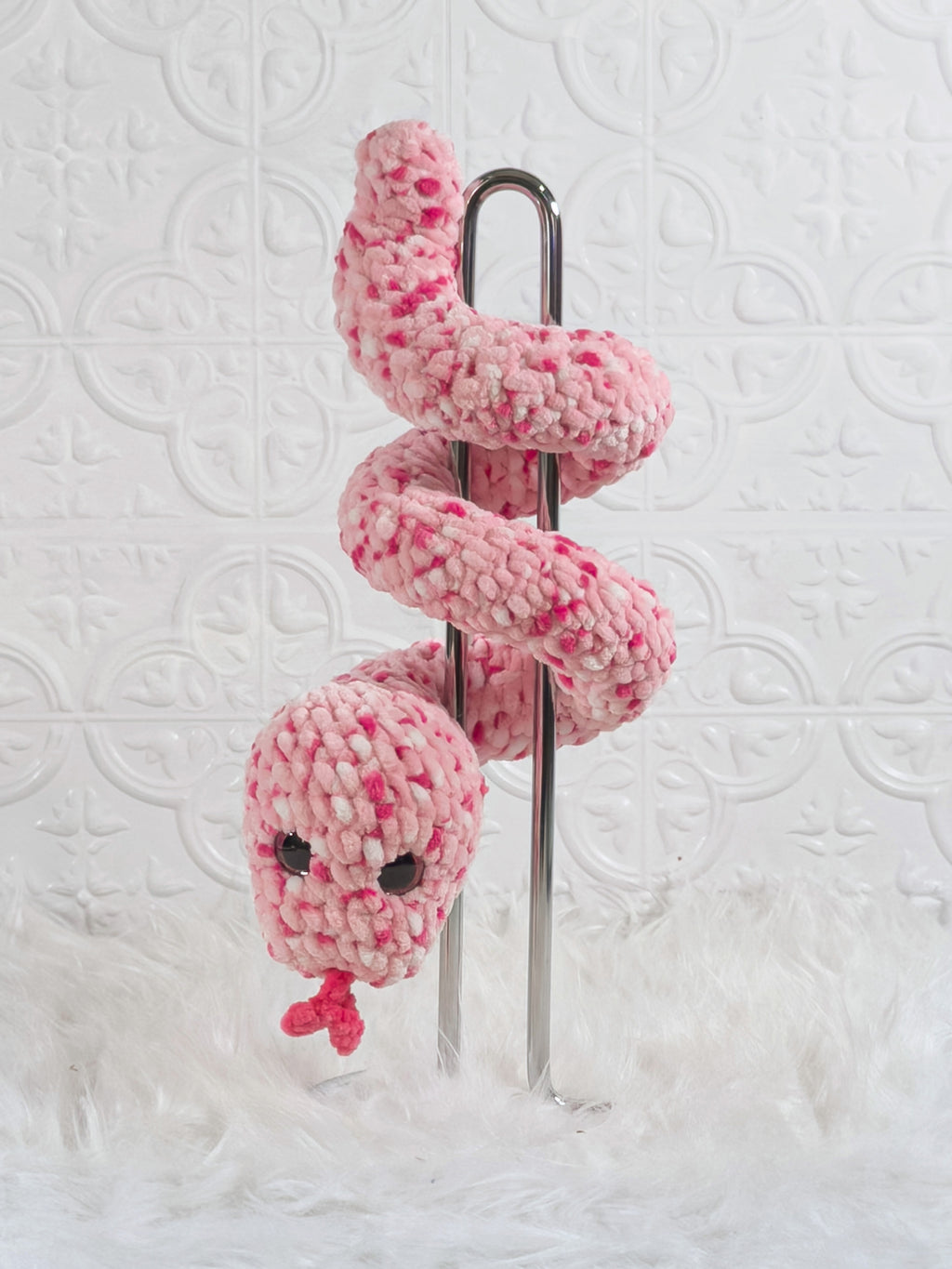 Handmade pink speckle snake crochet plushie shown from the back