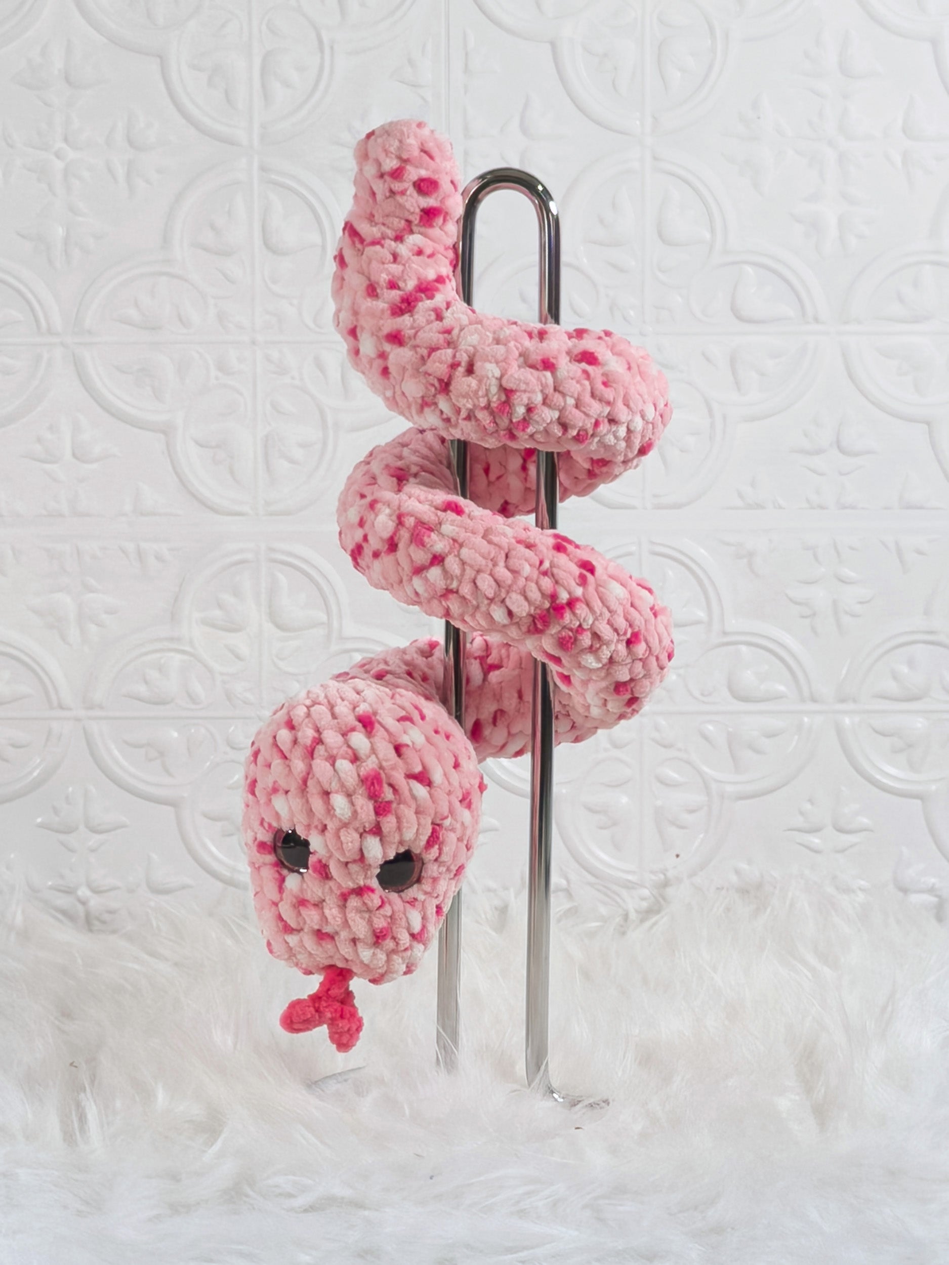 Handmade pink speckle snake crochet plushie shown from the back