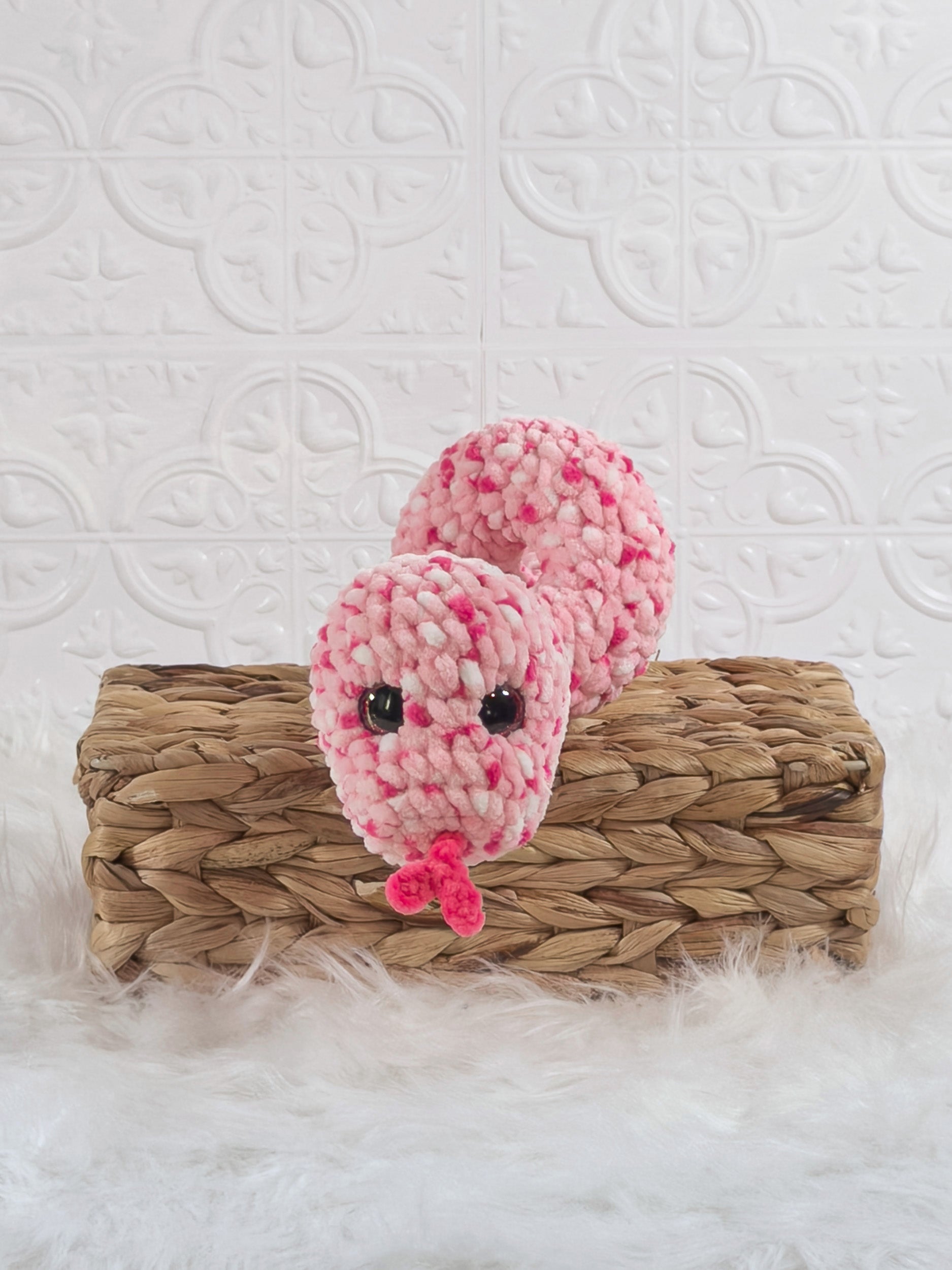 Handmade pink speckle snake crochet plushie shown from the front