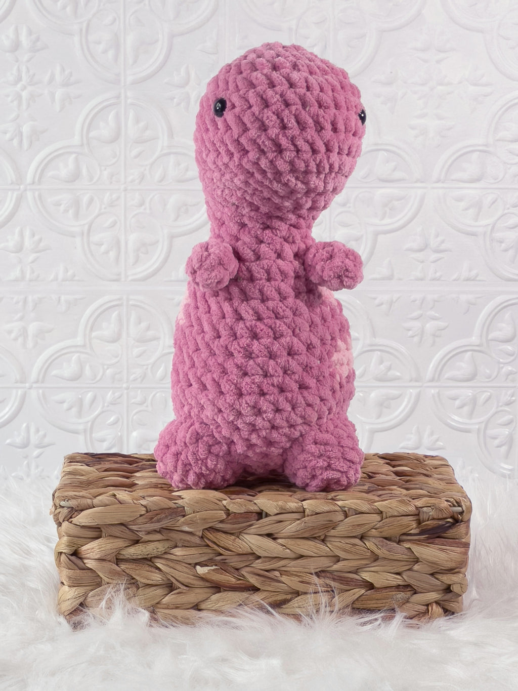 Handmade pink t rex crochet plushie shown from the front