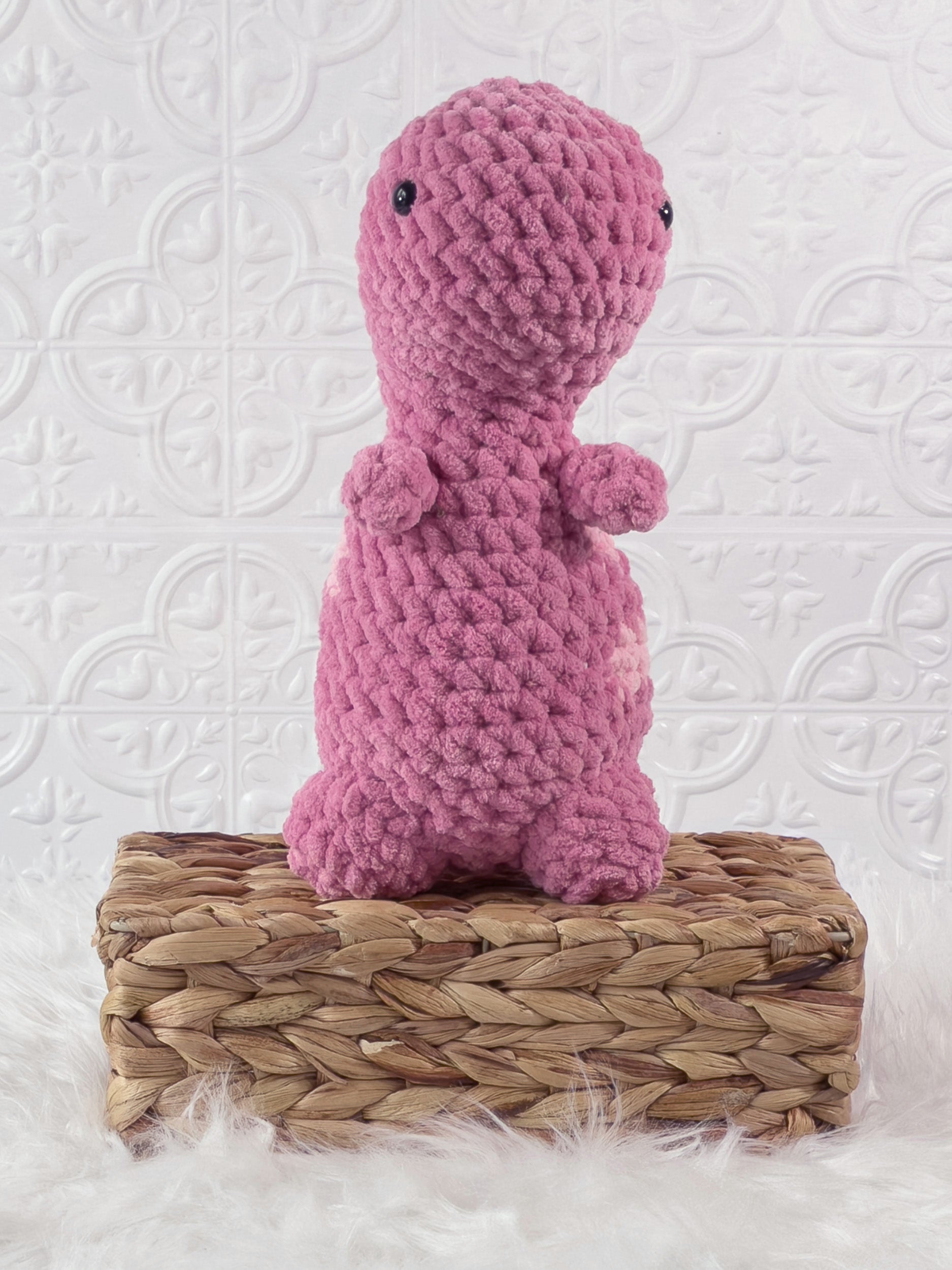 Handmade pink t rex crochet plushie shown from the front
