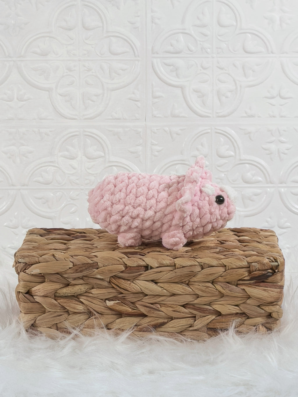 Handmade pink triceratops crochet plushie shown from the back