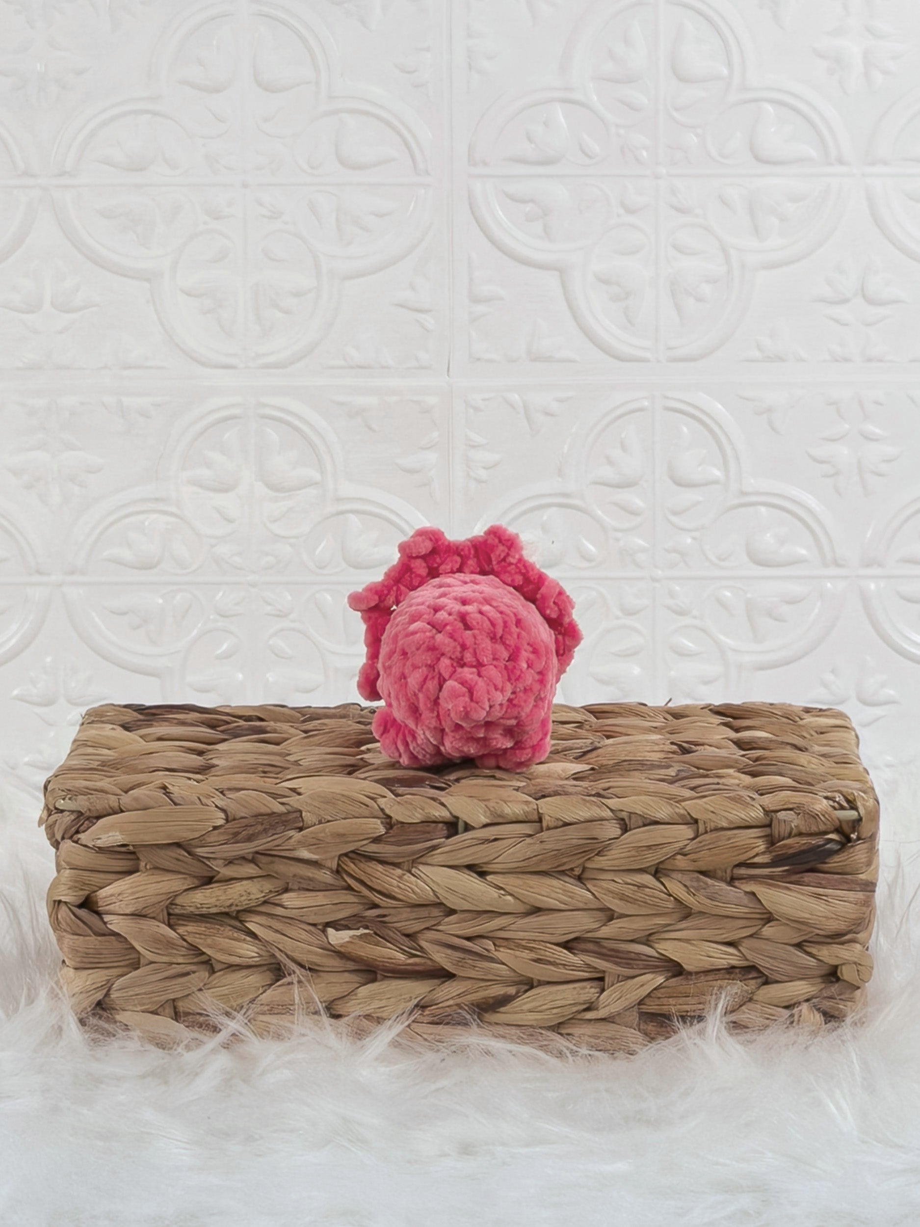 Handmade pink triceratops crochet plushie shown from the back