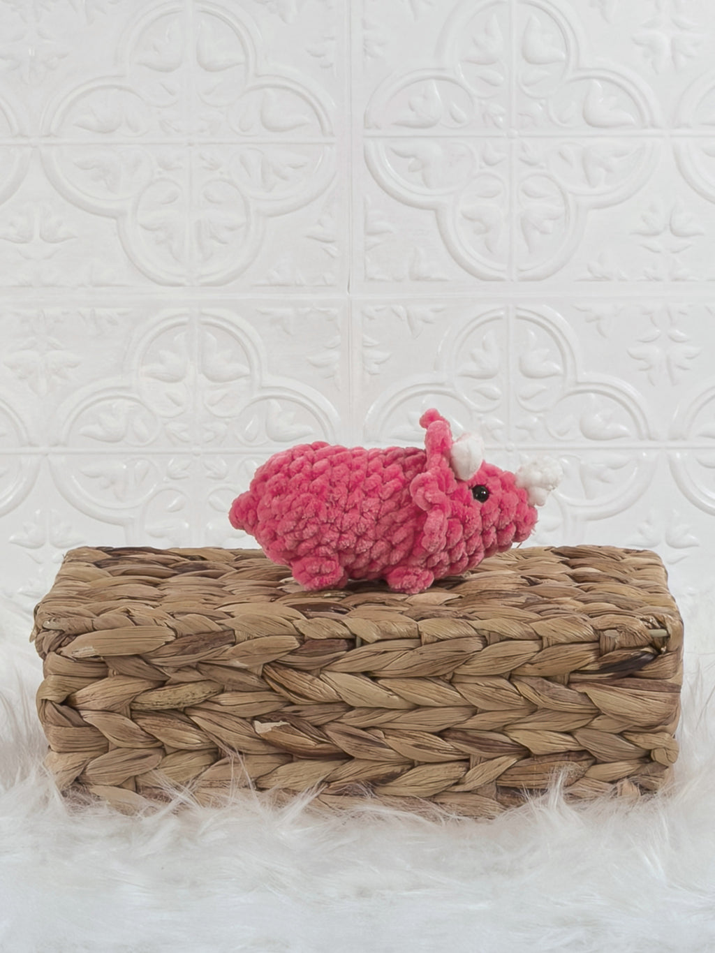 Handmade pink triceratops crochet plushie shown from the side