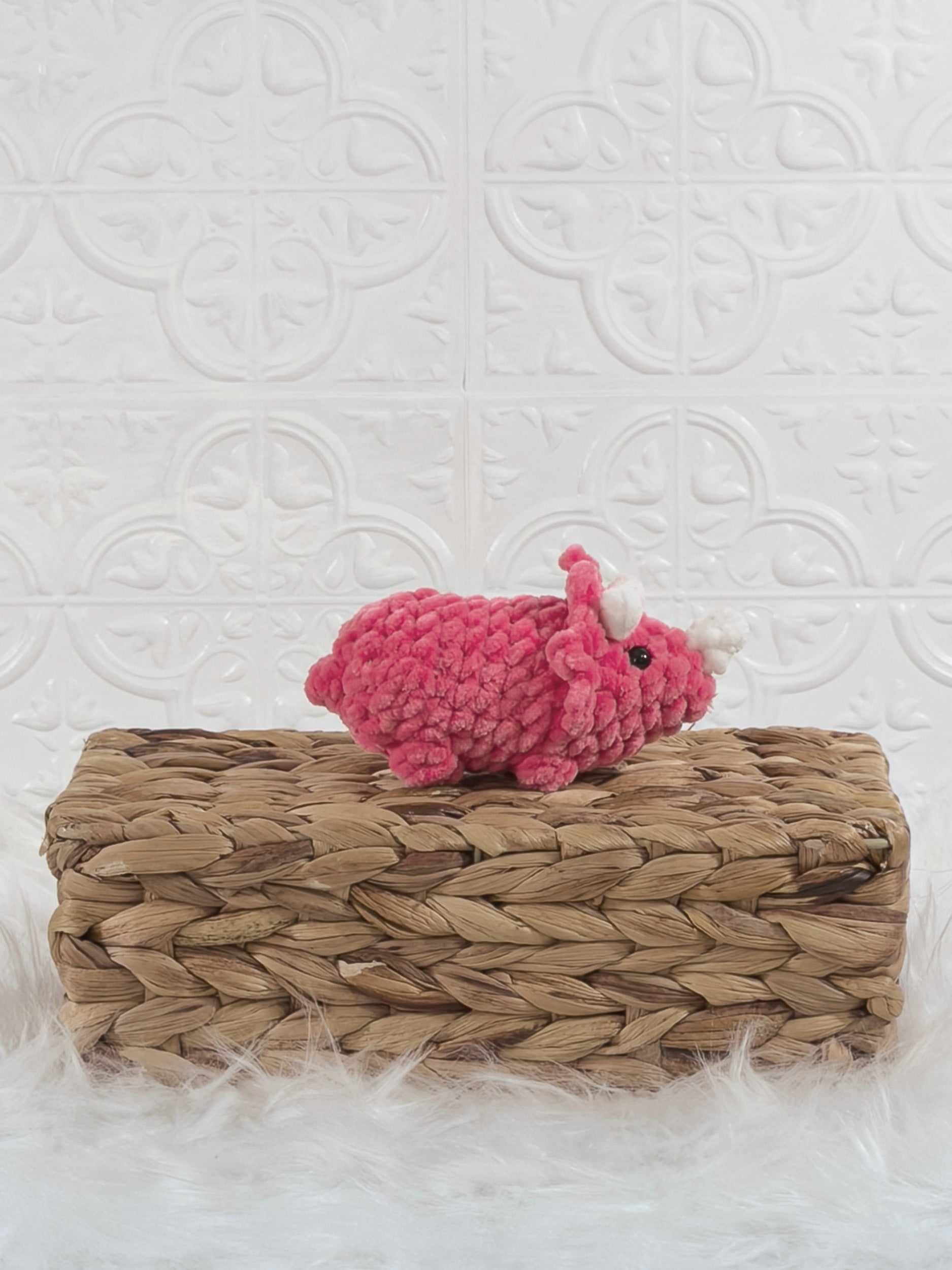 Handmade pink triceratops crochet plushie shown from the side