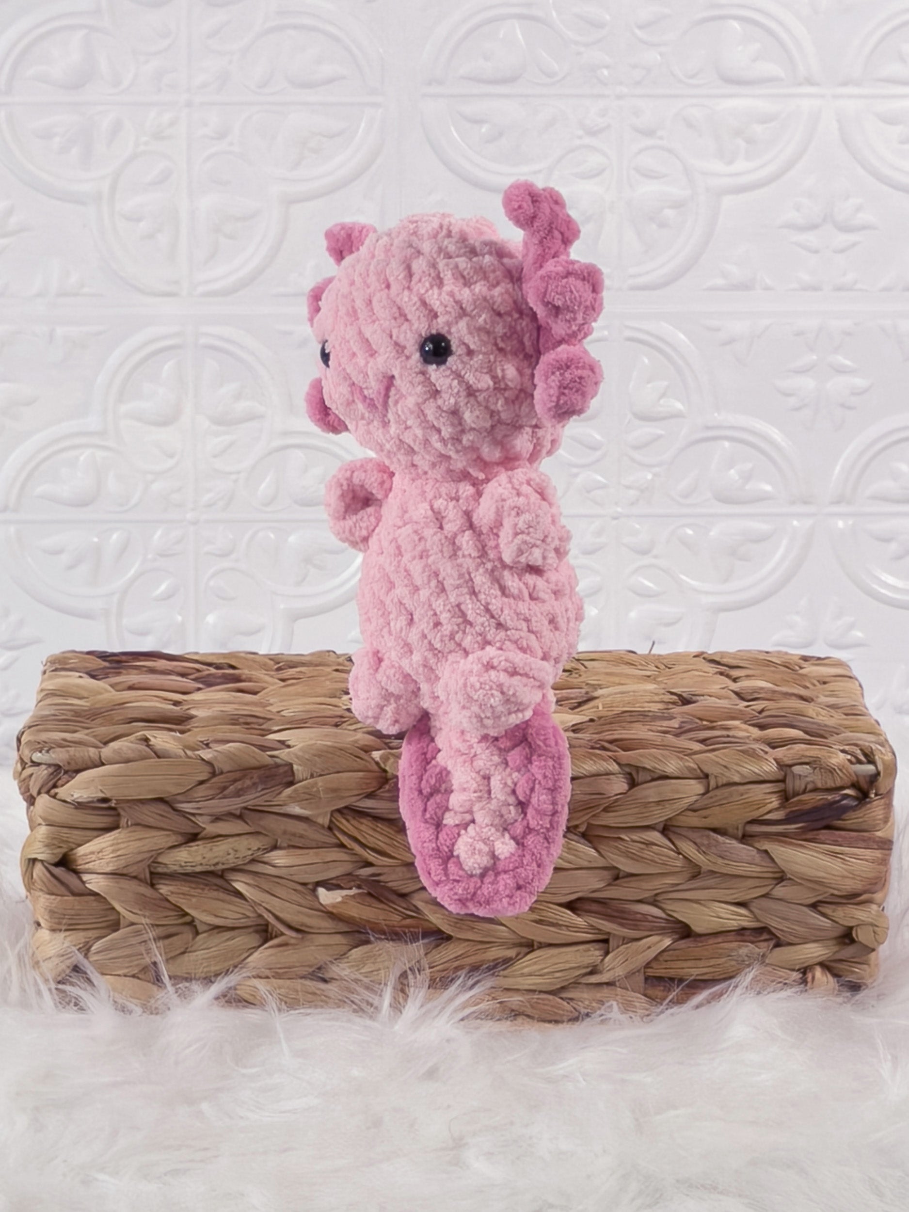 Handmade pink , dark axolotl crochet plushie shown from the front