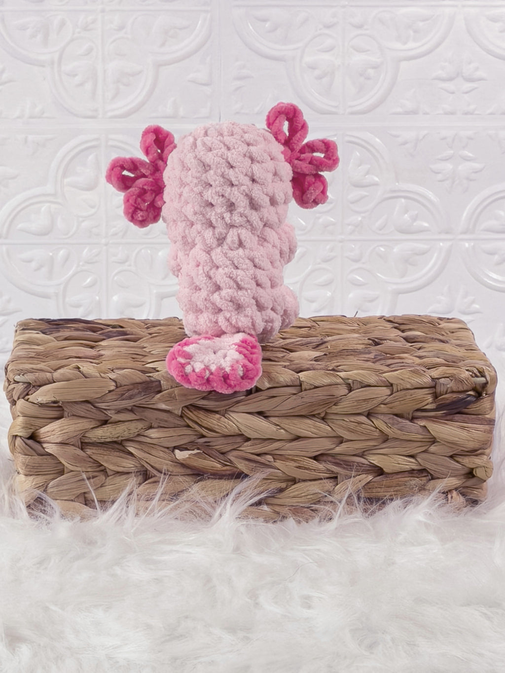Handmade pink, light axolotl crochet plushie shown from the back