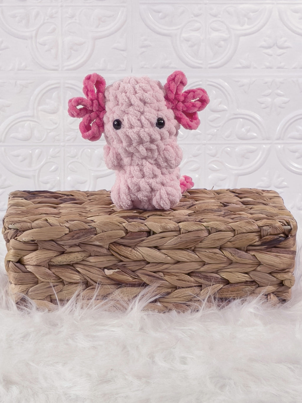 Handmade pink, light axolotl crochet plushie shown from the front