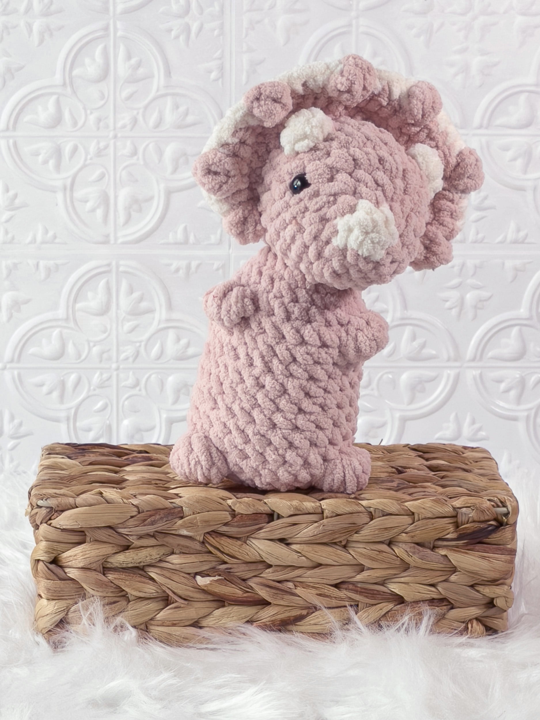 Handmade pink , light triceratops crochet plushie shown from the front
