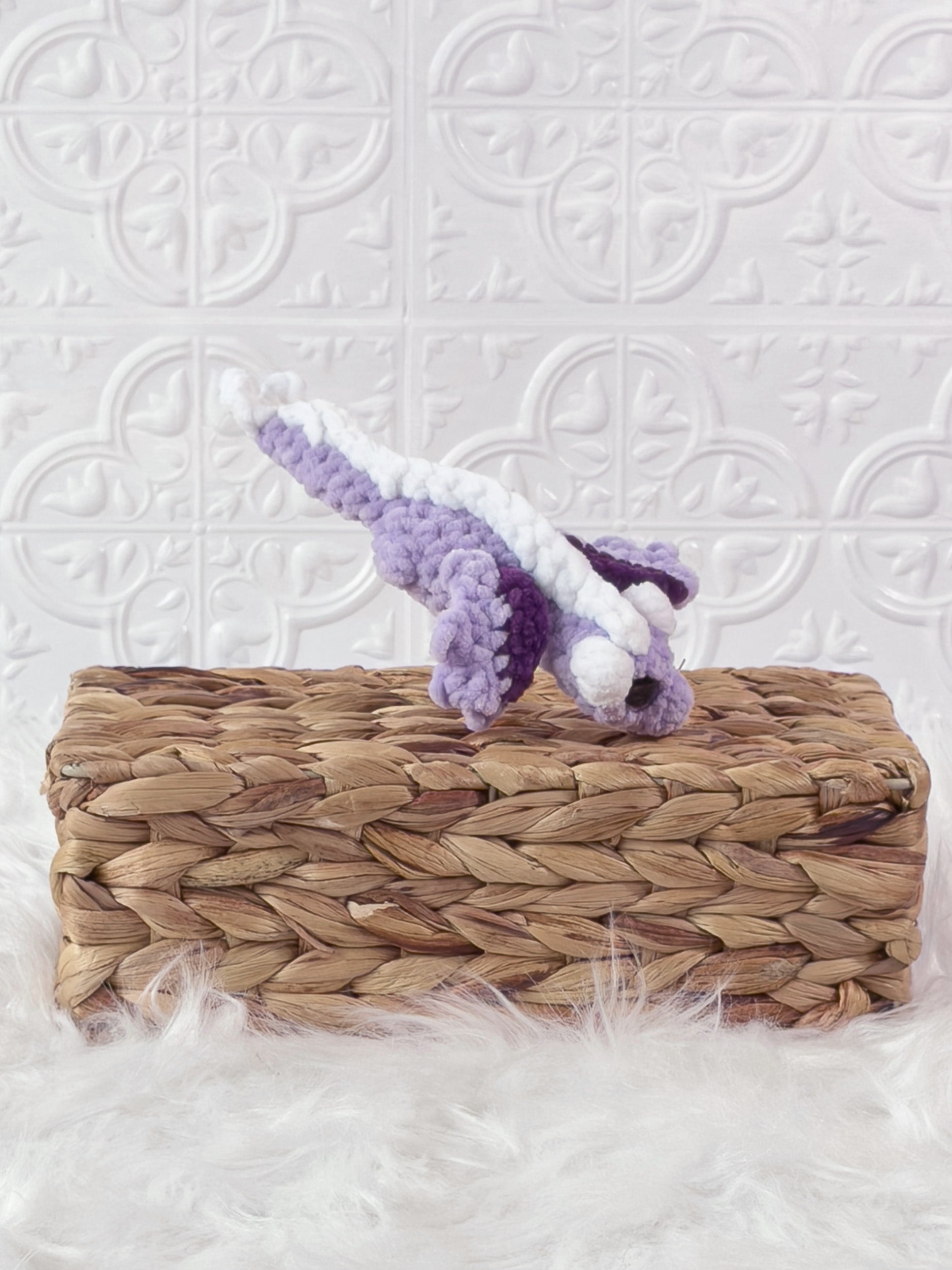 Handmade purple mini dragon crochet plushie shown from an angled view