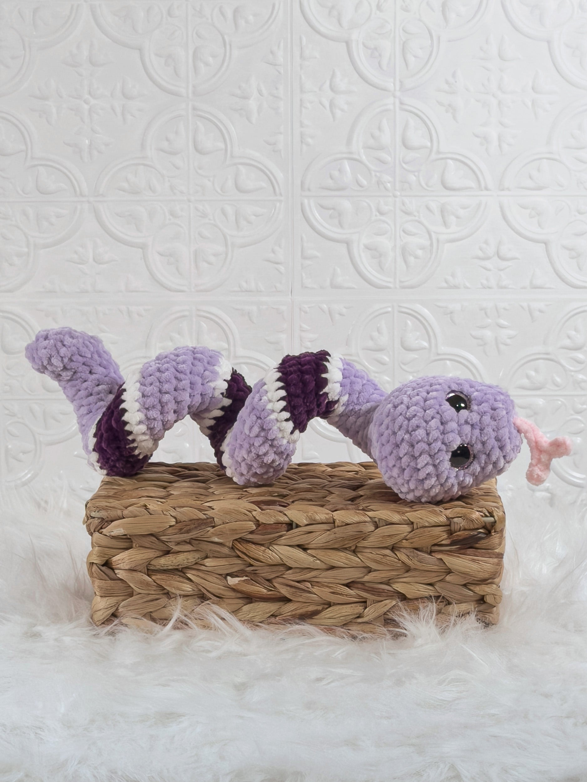 Handmade purple snake crochet plushie shown from an angled view