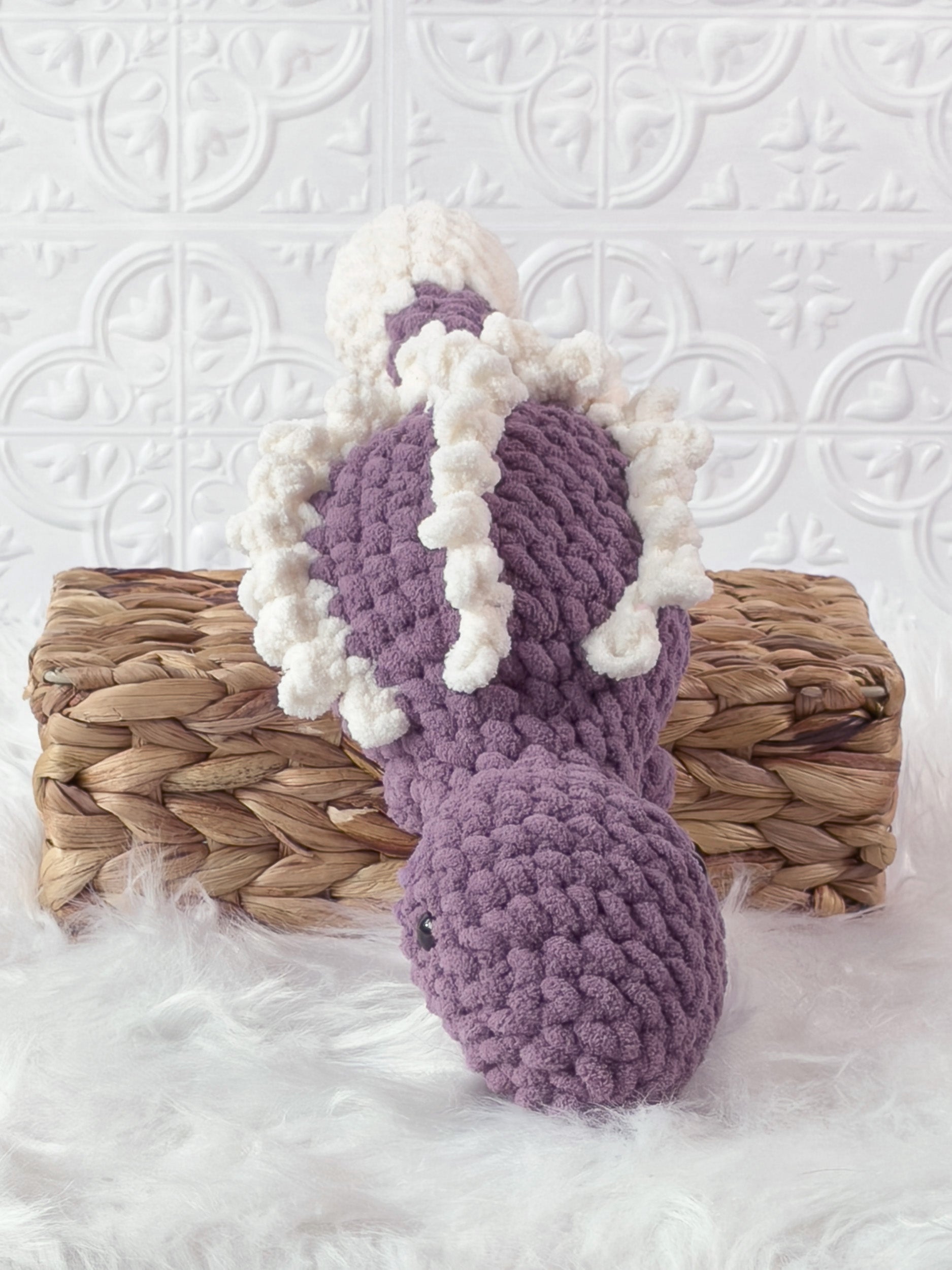 Handmade purple stegosaurus crochet plushie shown from the front