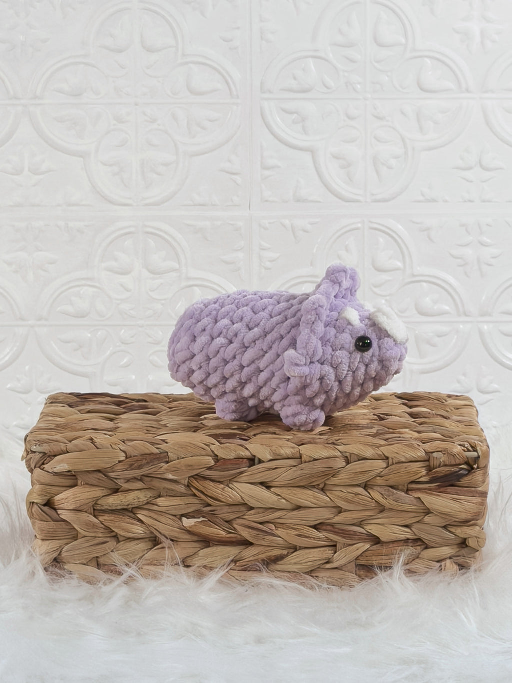 Handmade purple triceratops crochet plushie shown from an angled view