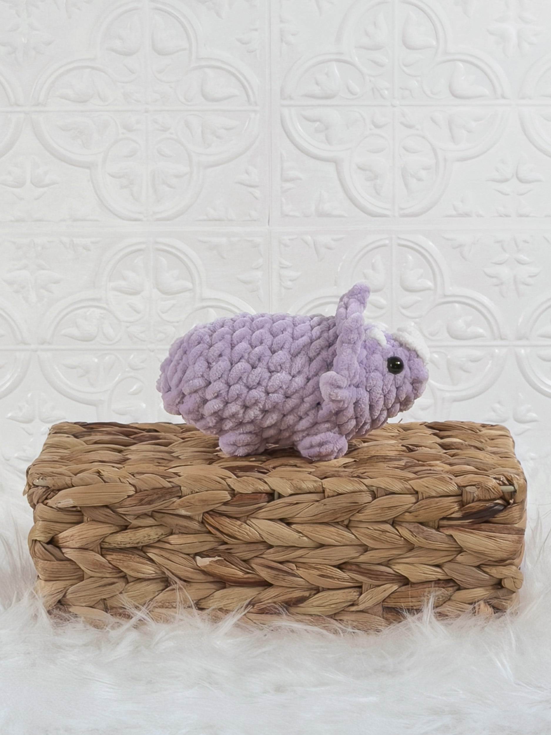 Handmade purple triceratops crochet plushie shown from the side