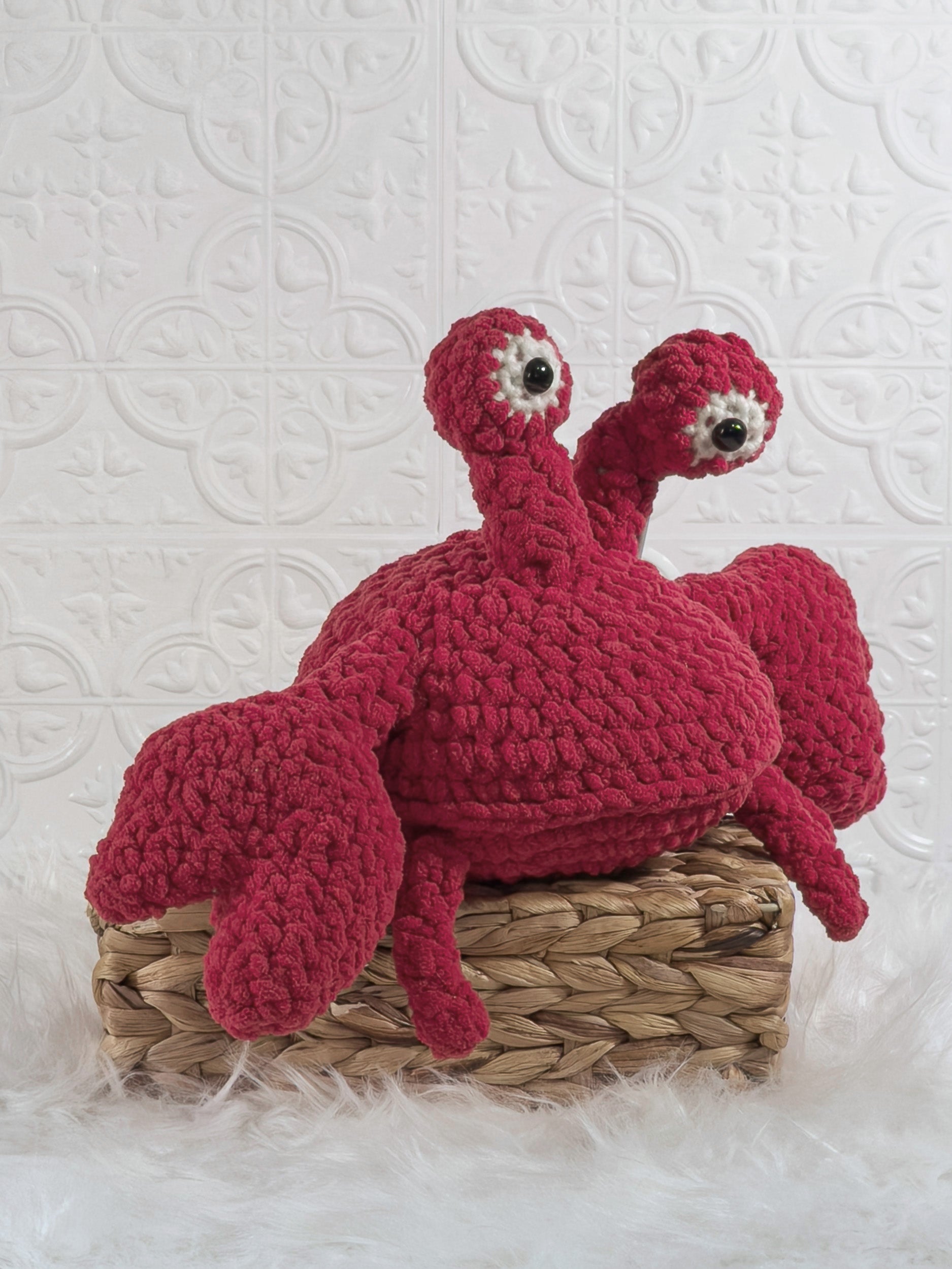 Handmade red crab crochet plushie shown from an angled view