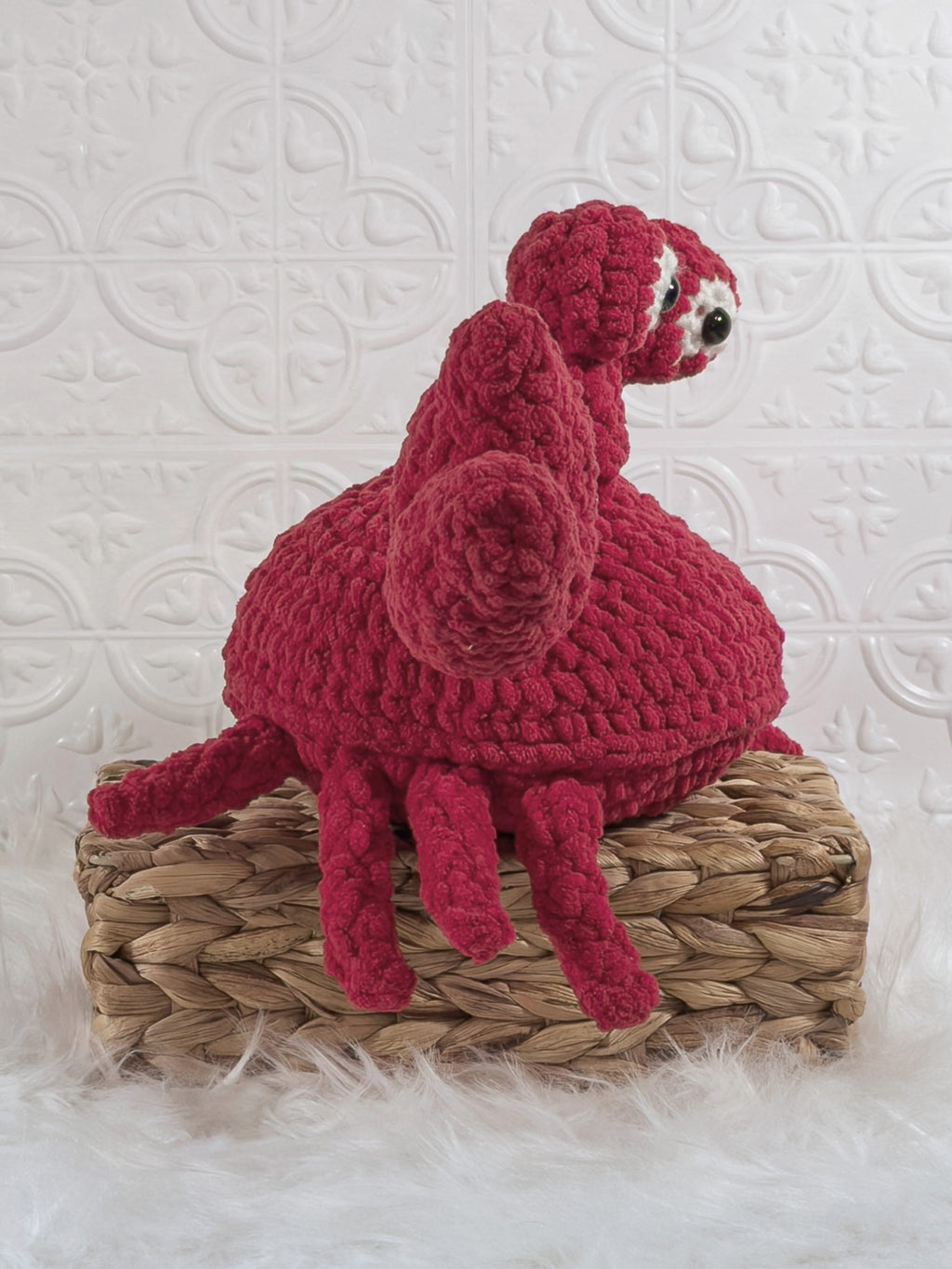 Handmade red crab crochet plushie shown from the side